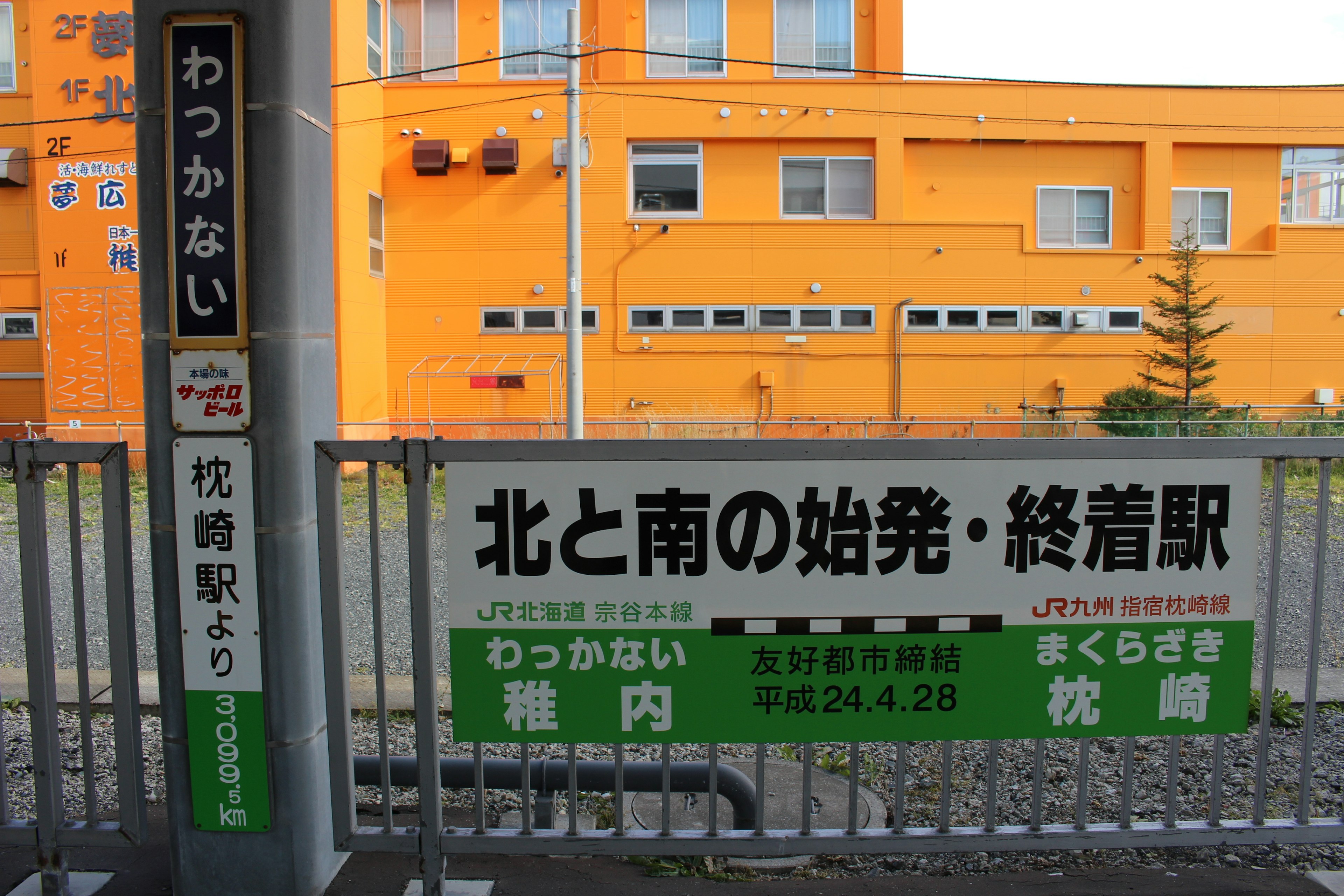 Wakkanai Station sign with orange building background