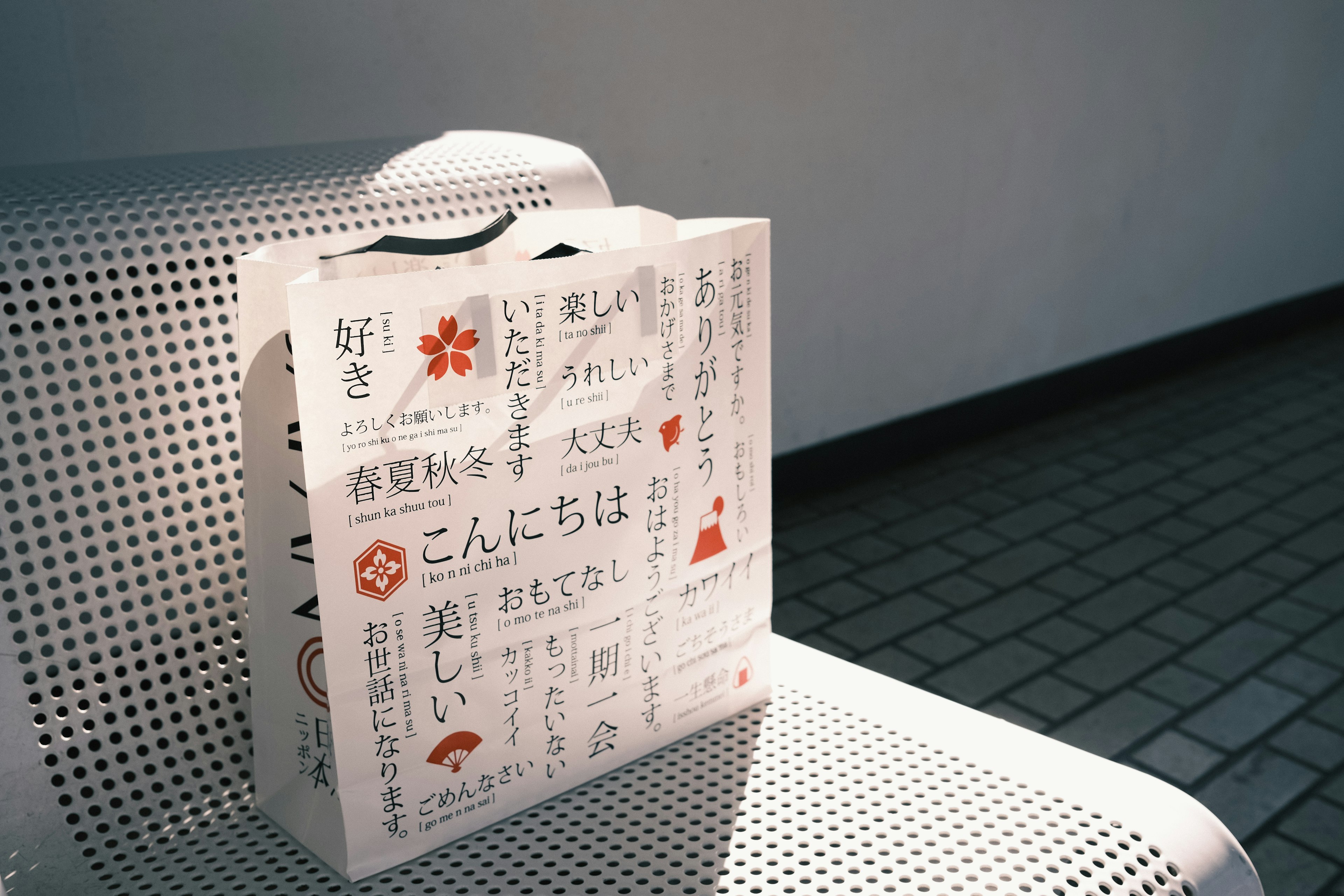 White paper bag featuring Japanese text and floral designs