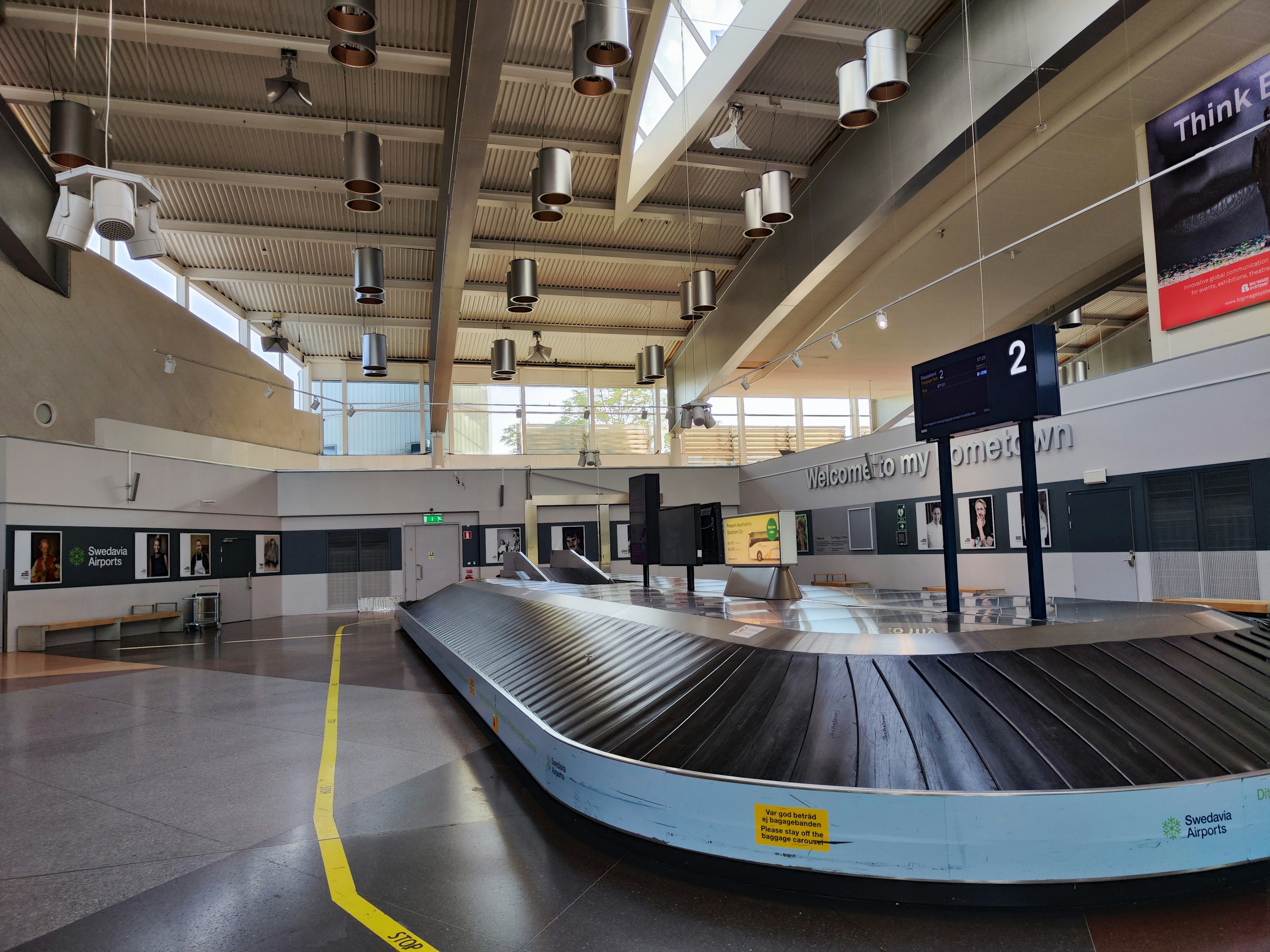 Spacious airport baggage claim area featuring bright lighting and high ceilings