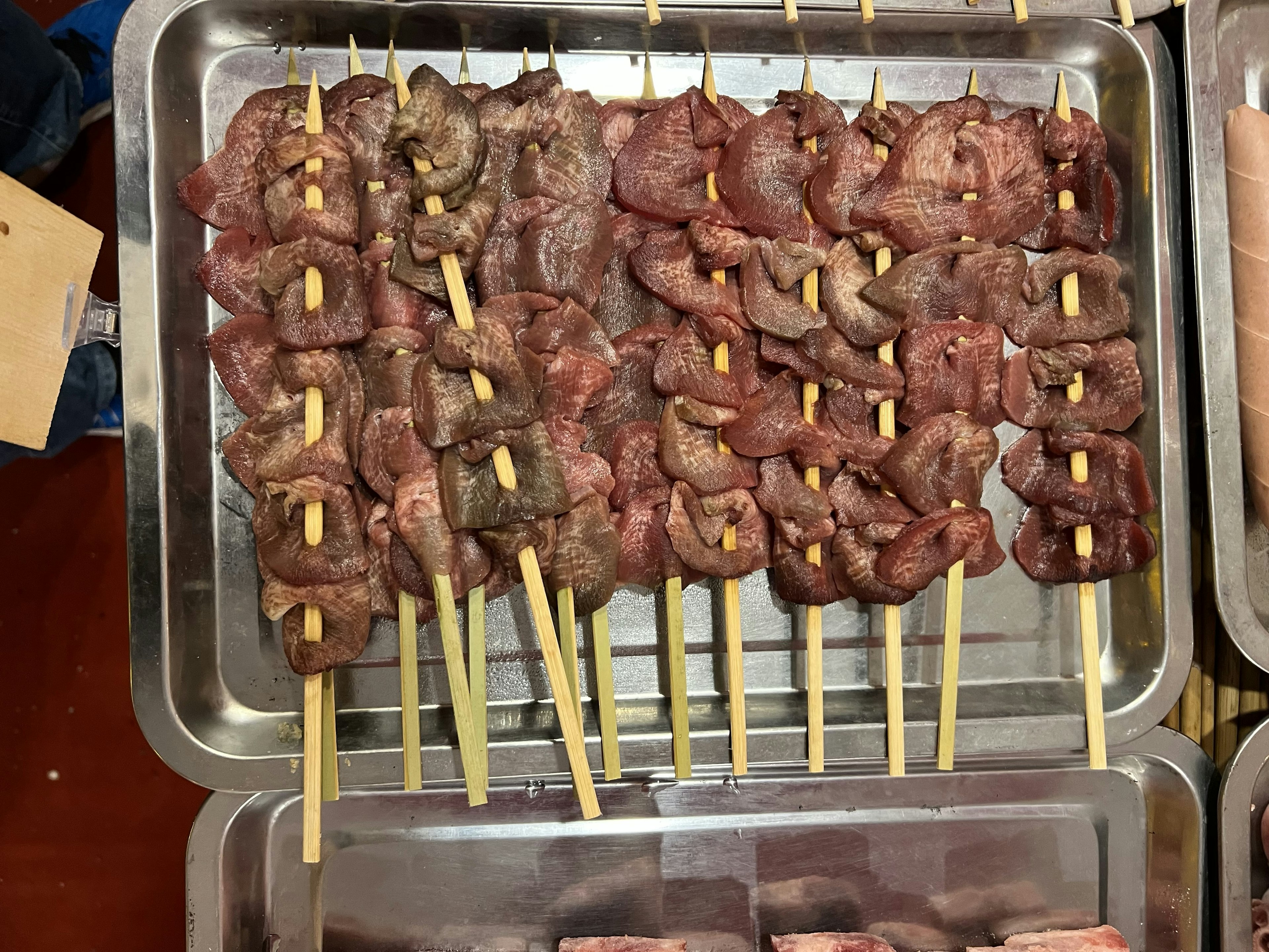 Brochetas de carne marinada dispuestas en una bandeja