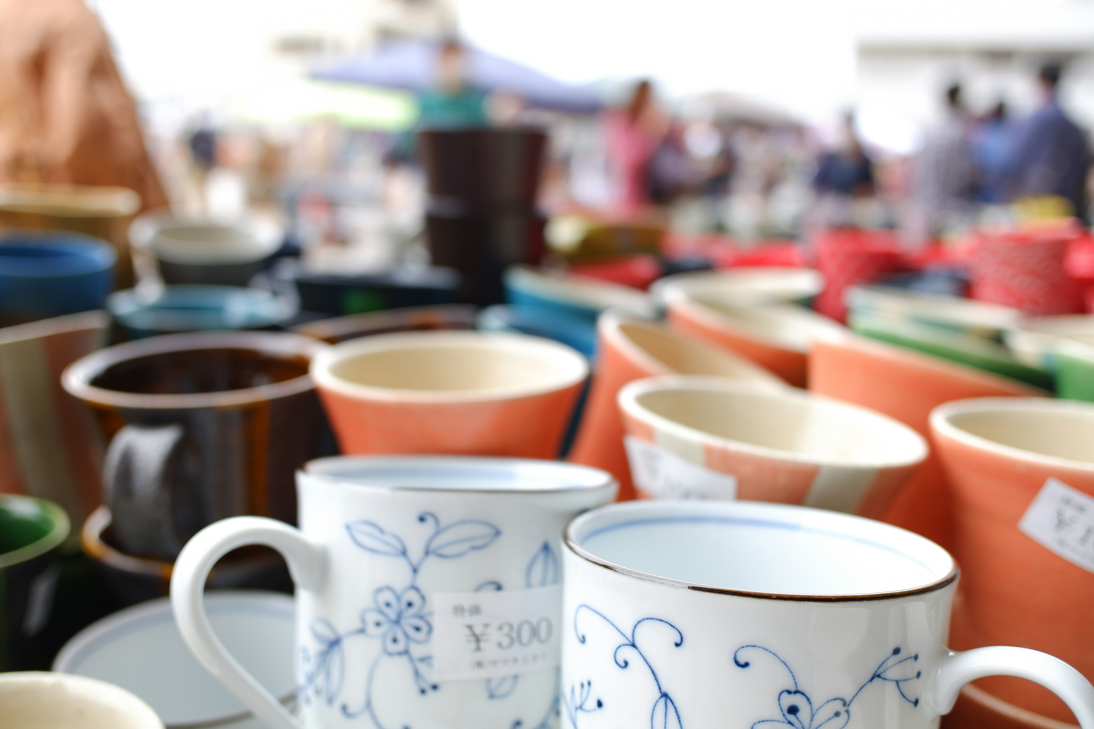 Bunte Keramiktassen und Töpfe auf einem Markt ausgestellt