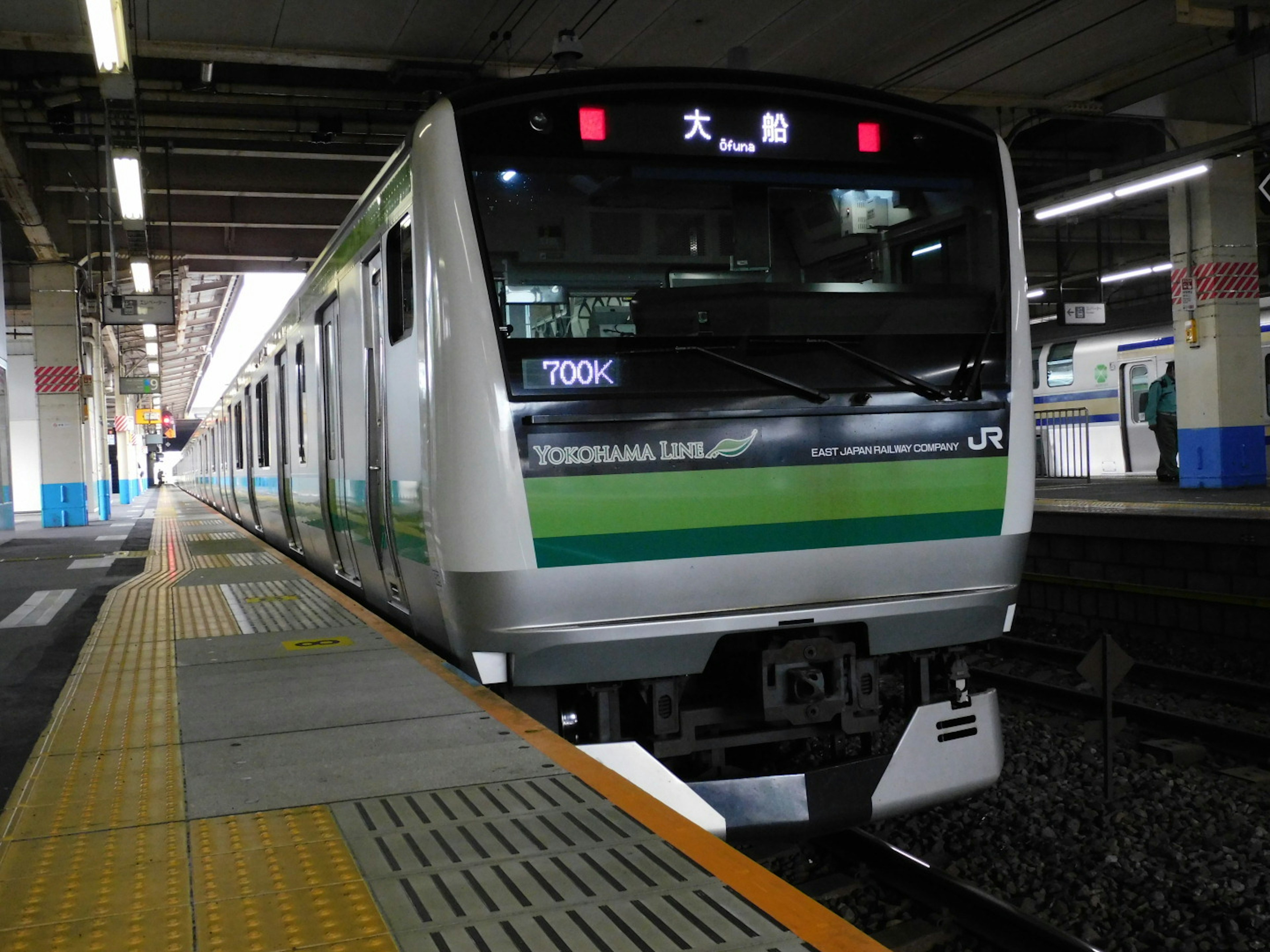 Kereta JR hijau dan putih berhenti di stasiun