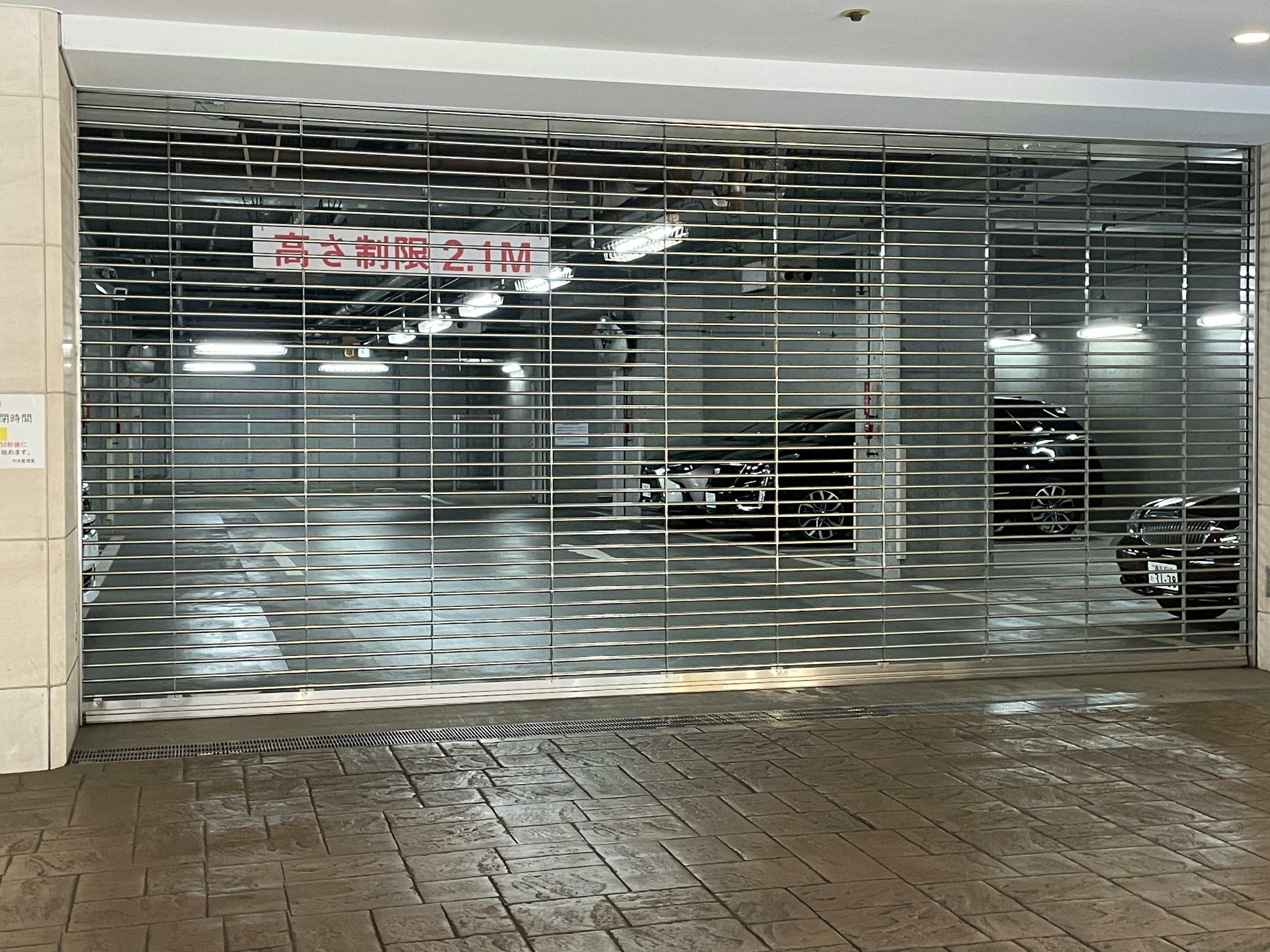 Closed garage entrance with metal shutter and interior lights