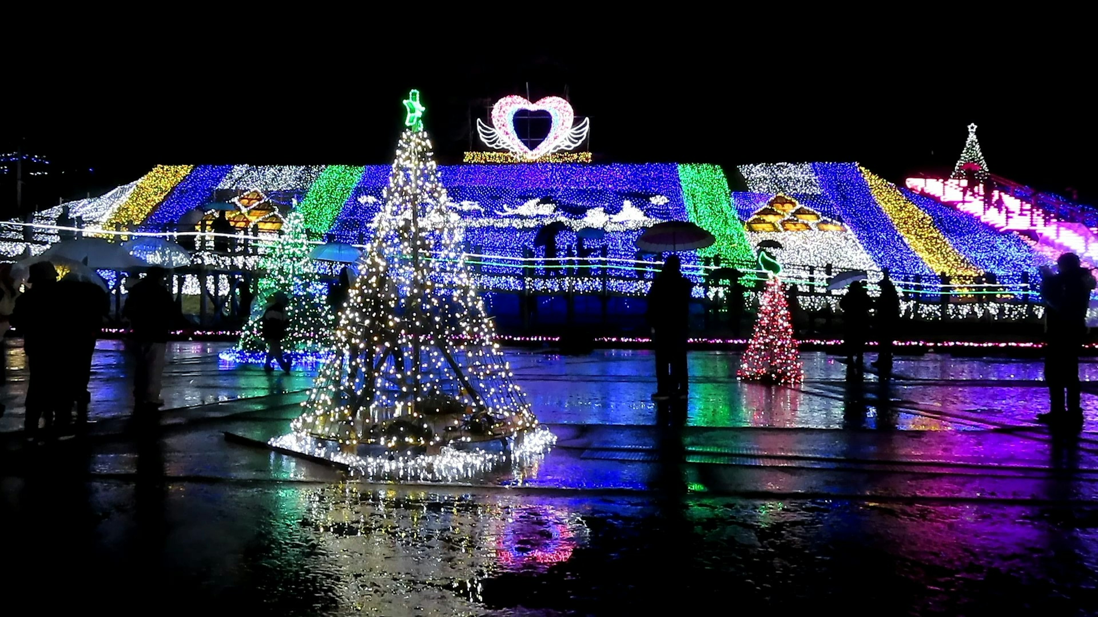 Wunderschöne Weihnachtslichter, die ein Gebäude mit dekorierten Bäumen schmücken