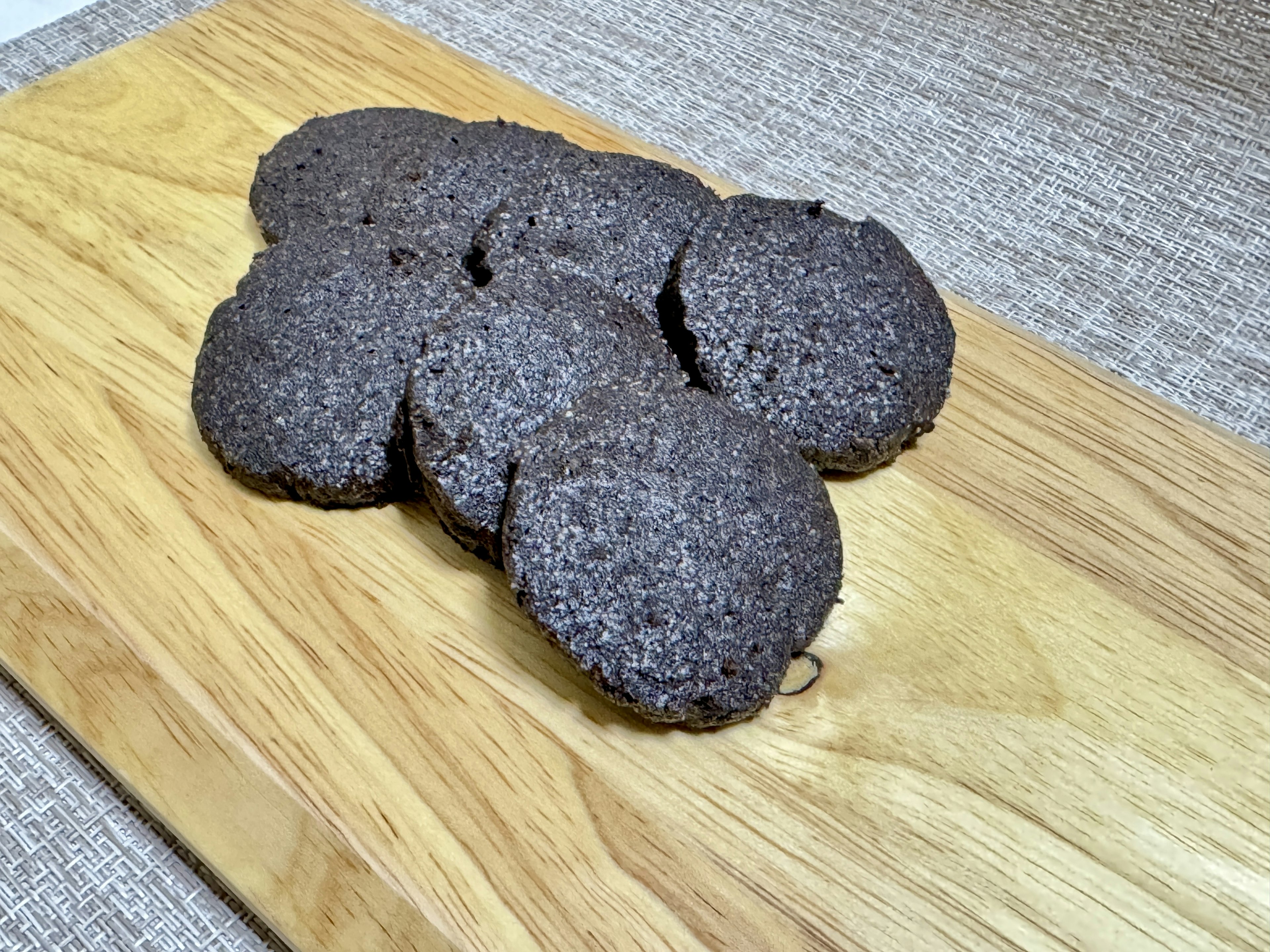 A group of dark cookies on a wooden board