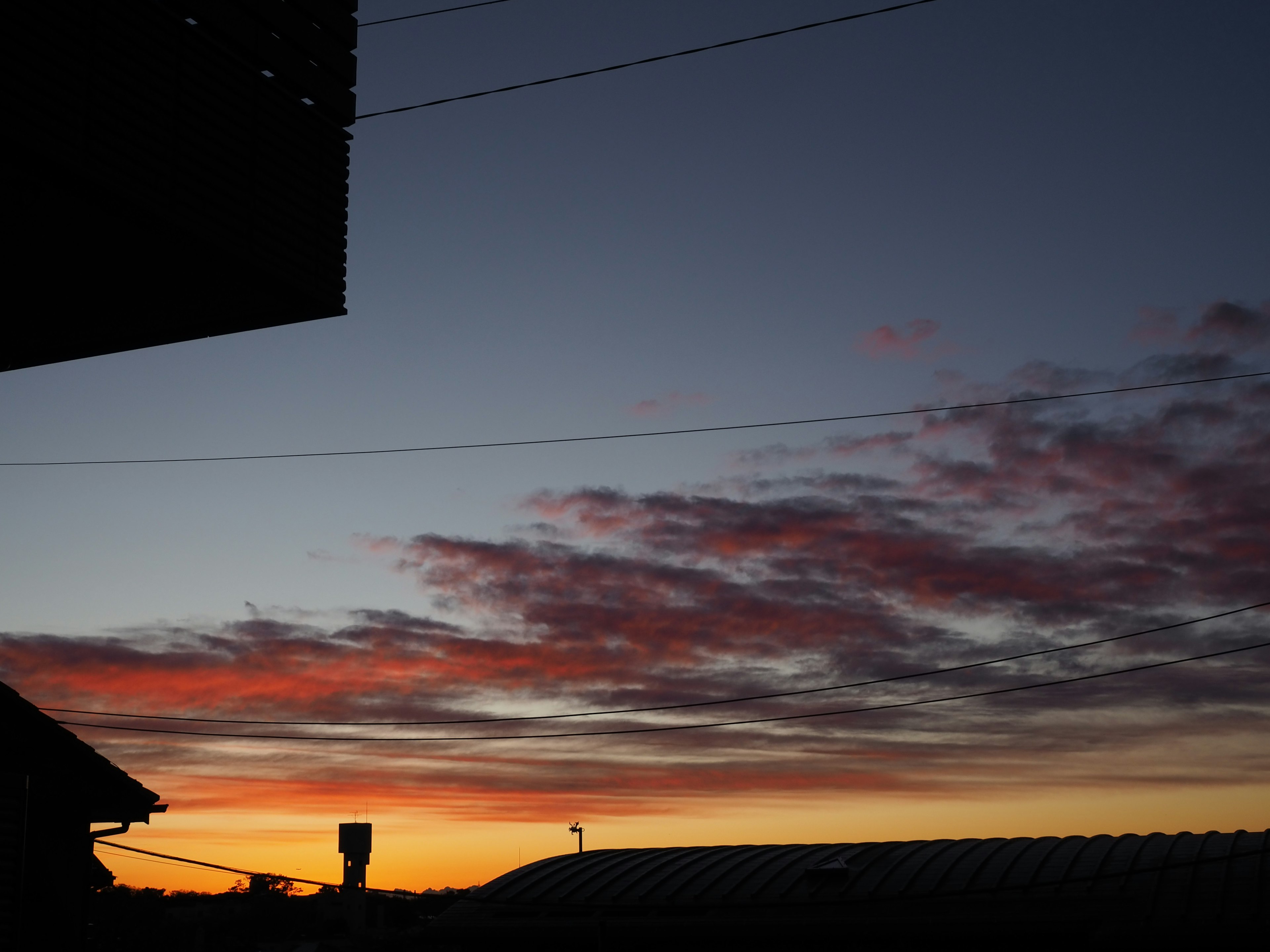 Nuvole colorate in un cielo al tramonto con silhouette di edifici