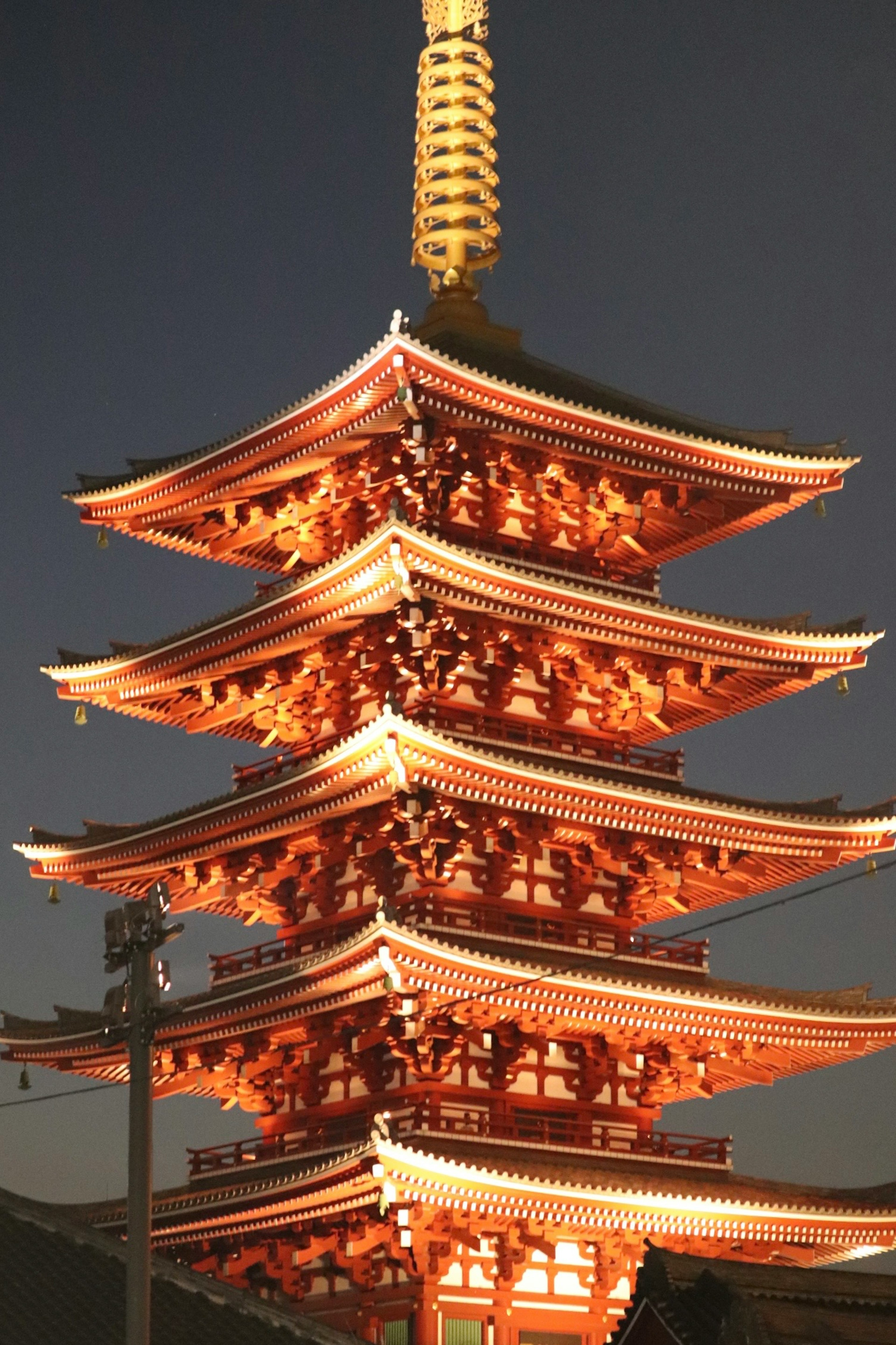 Warna merah yang indah dan desain rumit dari pagoda lima lantai Kuil Sensoji di malam hari