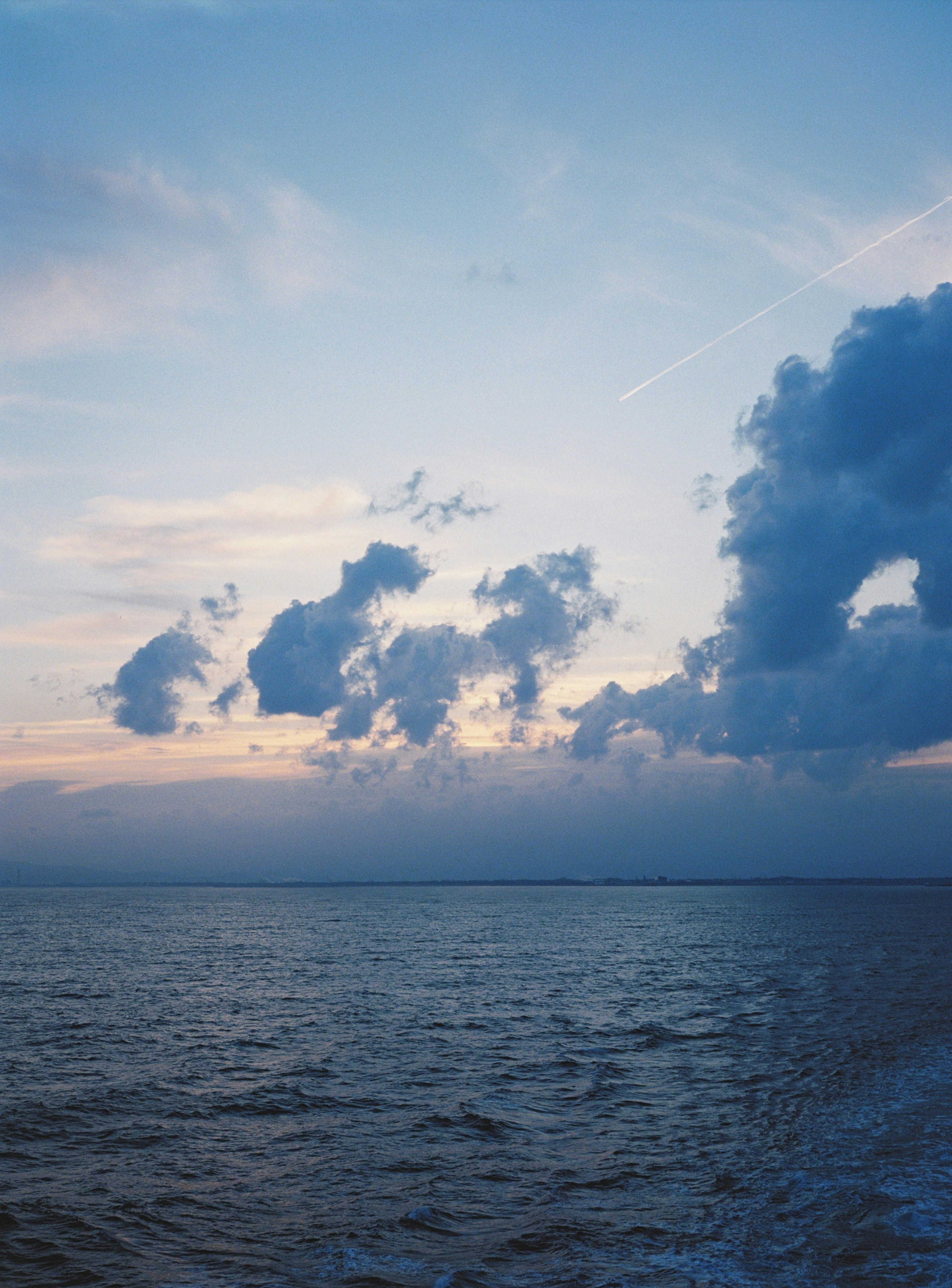 青い海と夕焼けの空に浮かぶ雲の風景