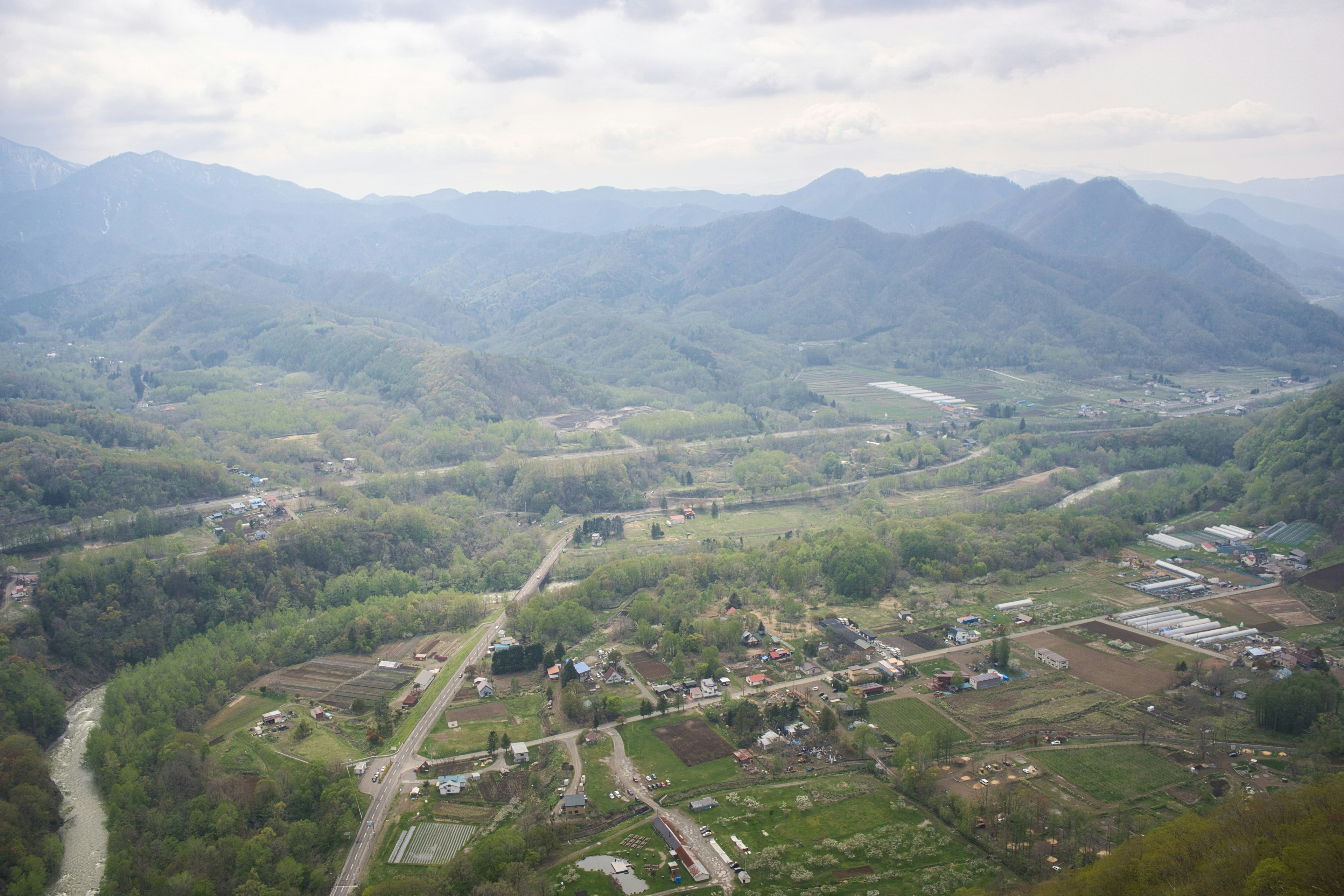 Paesaggio di valle verde e villaggio circondato da montagne