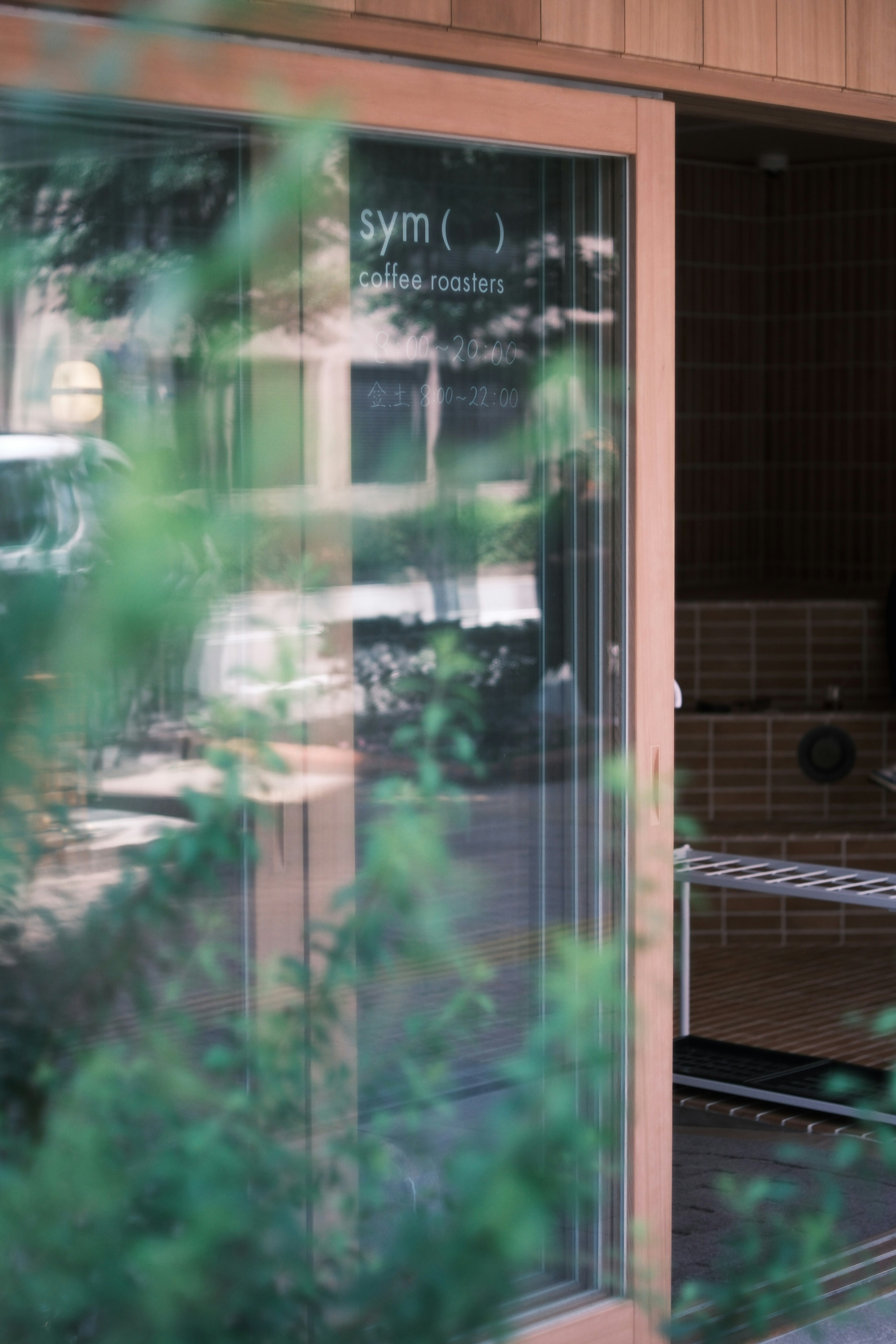 Glass door revealing gym interior with greenery