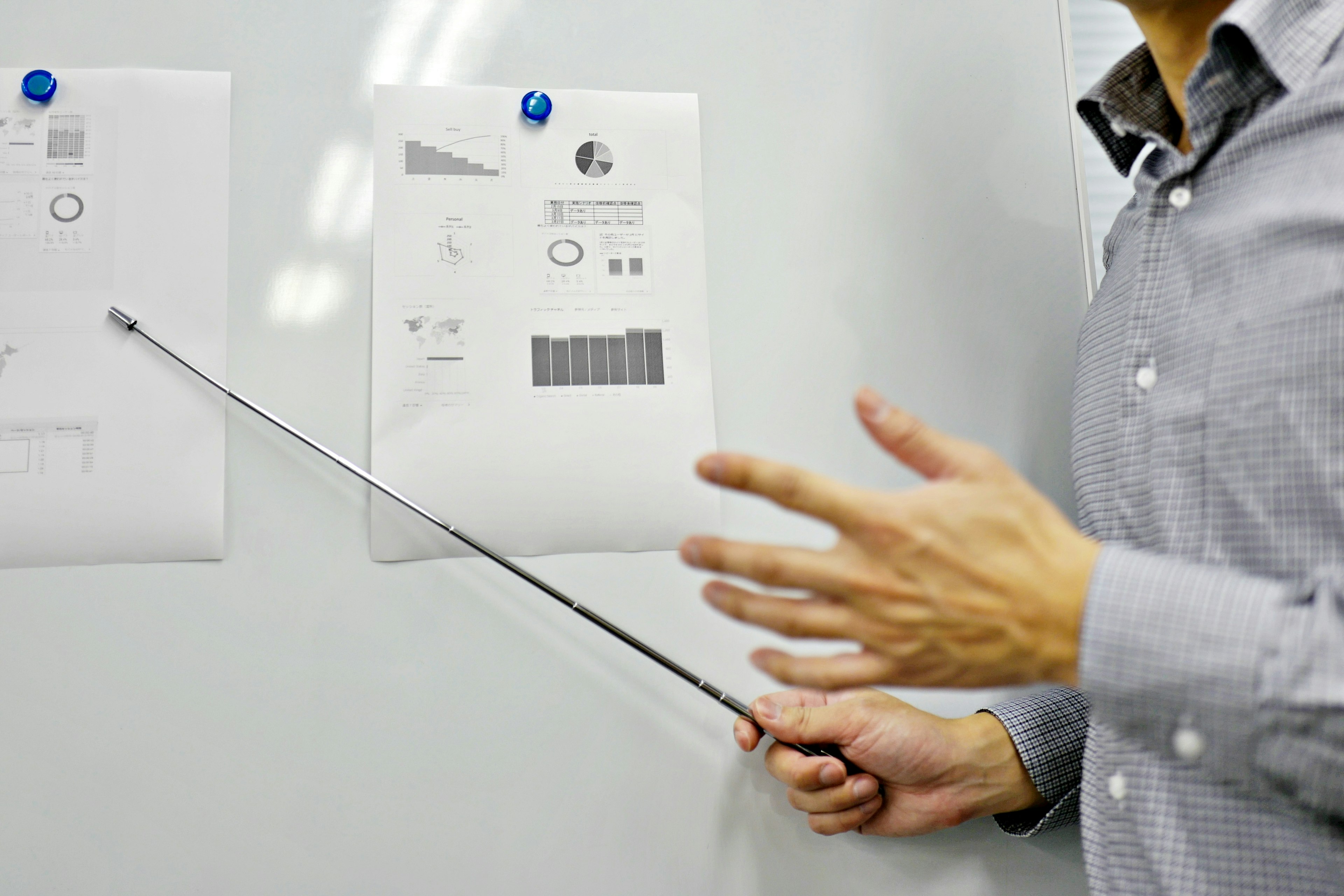 A person pointing at documents on a whiteboard