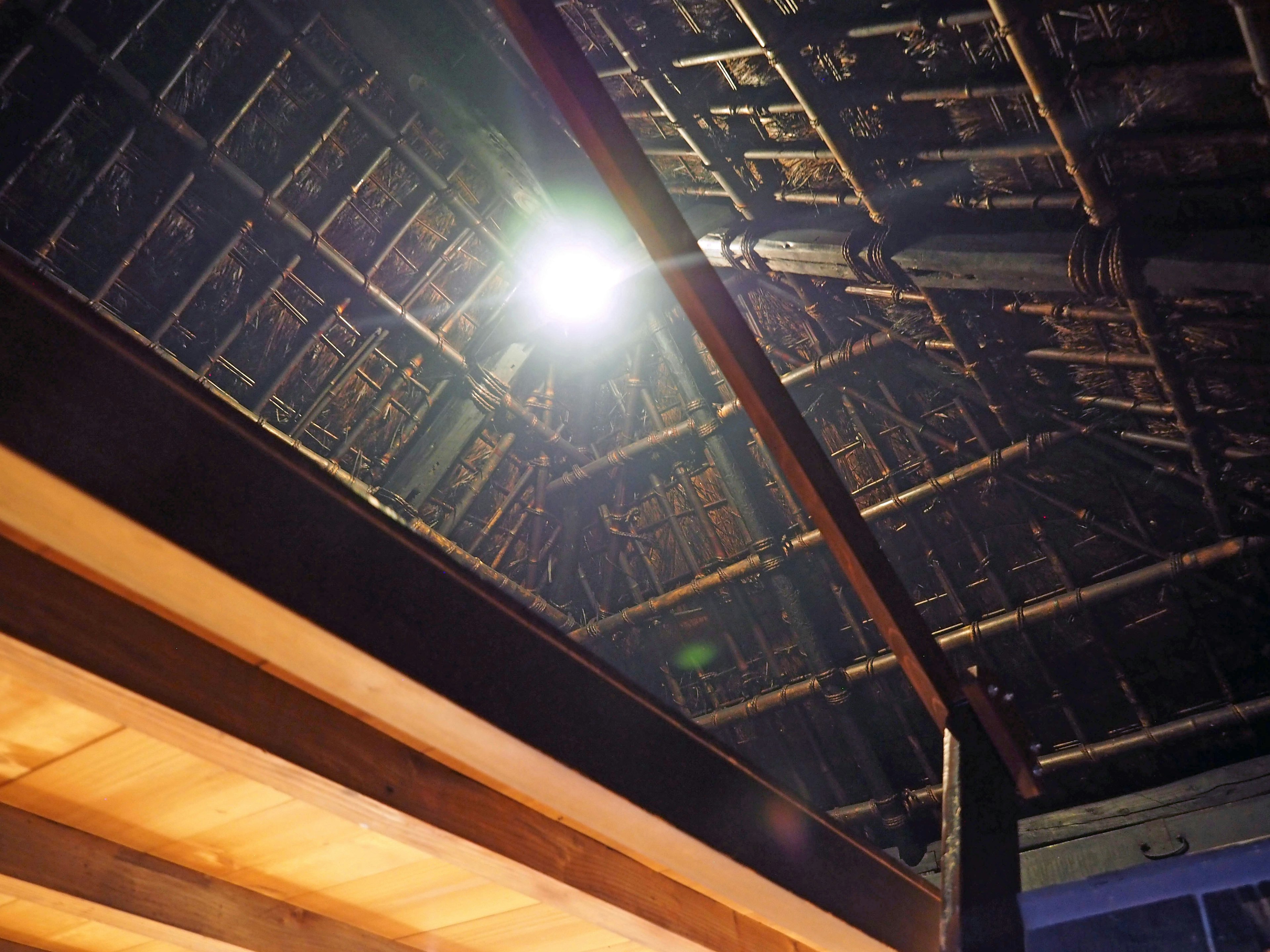 Foto que muestra la estructura interior de un techo con vigas de bambú luz brillante que entra