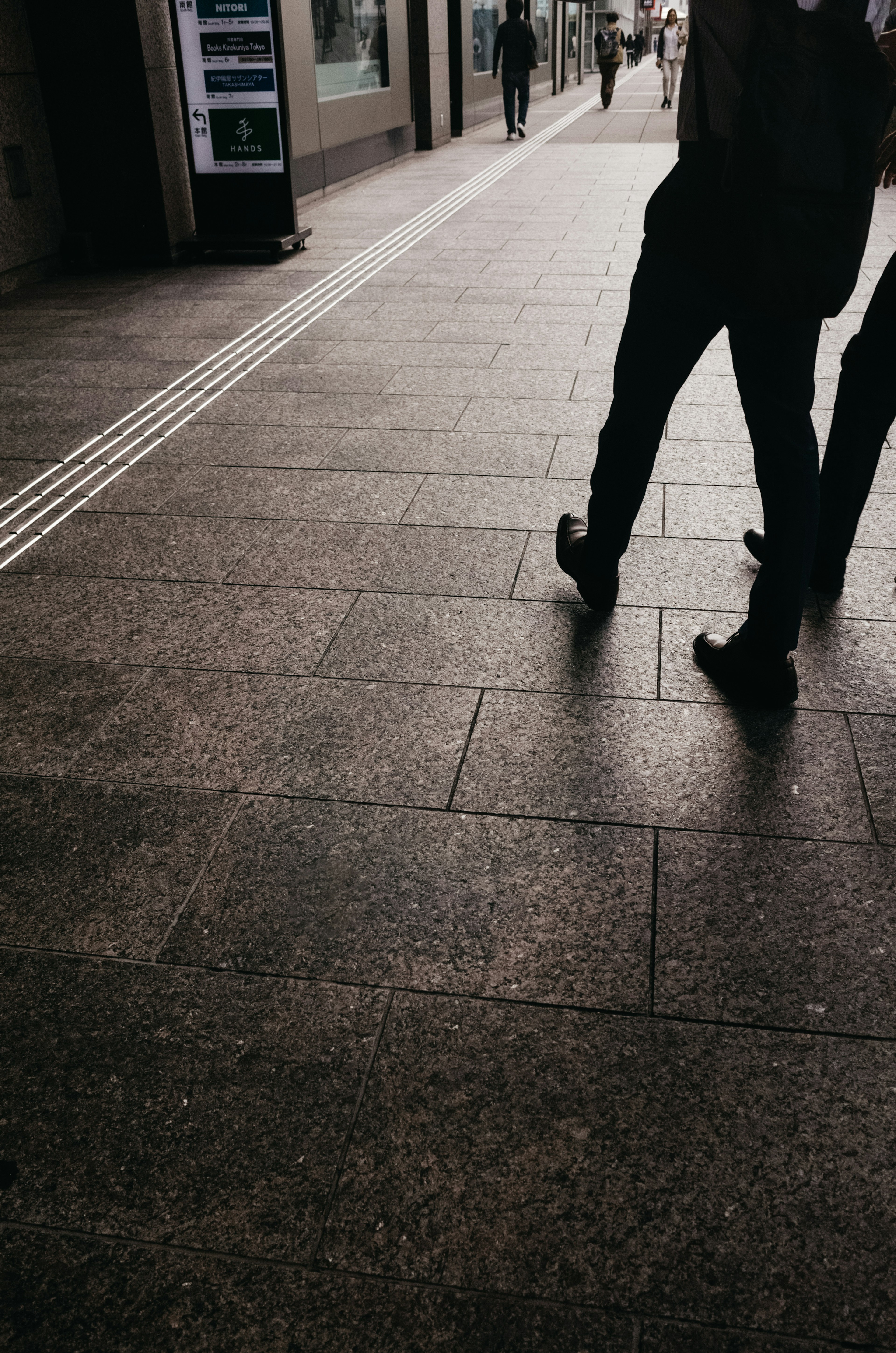 Silhouette di persone che camminano su una strada lastricata di pietre