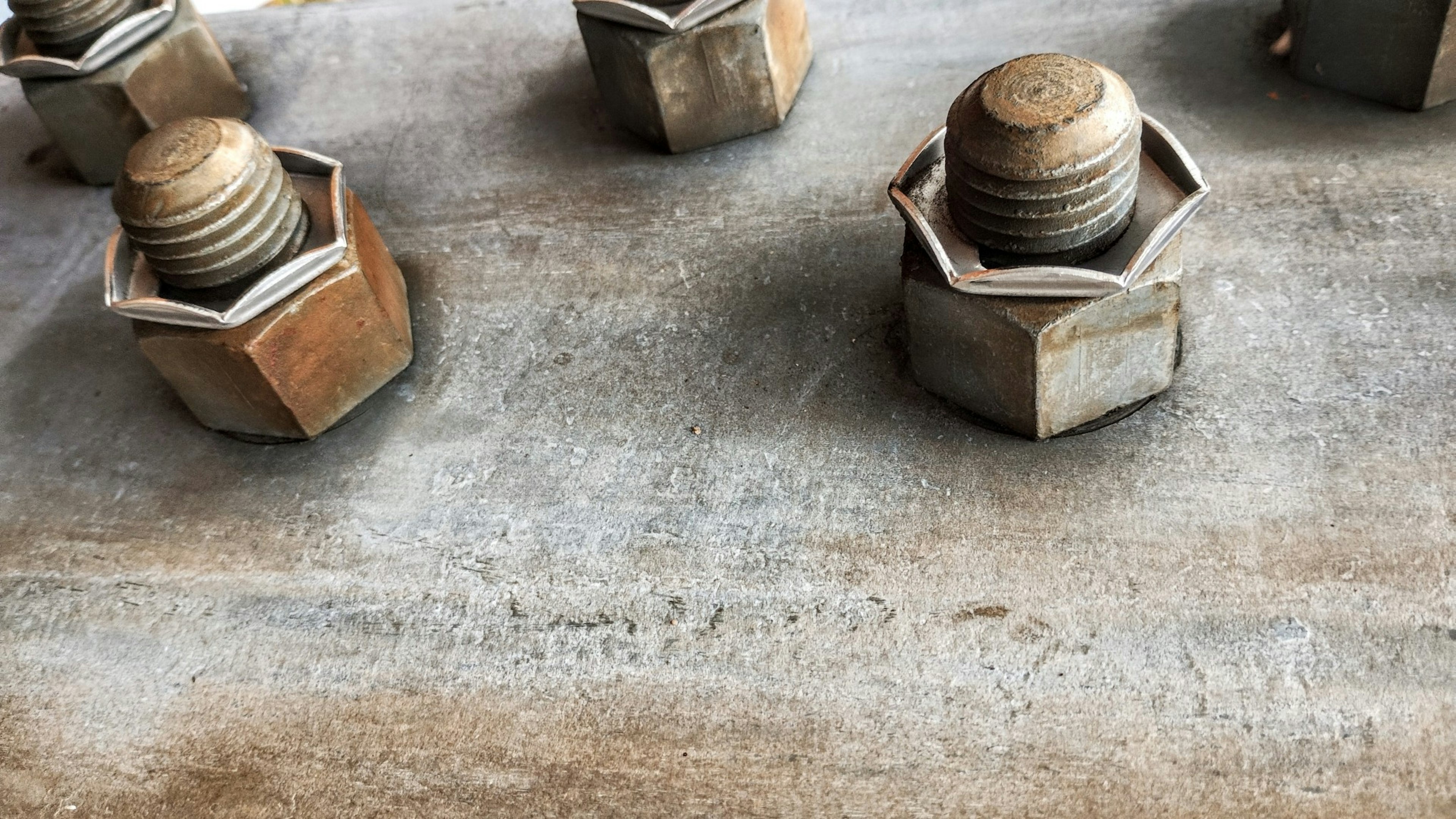 Boulons métalliques disposés sur une surface industrielle