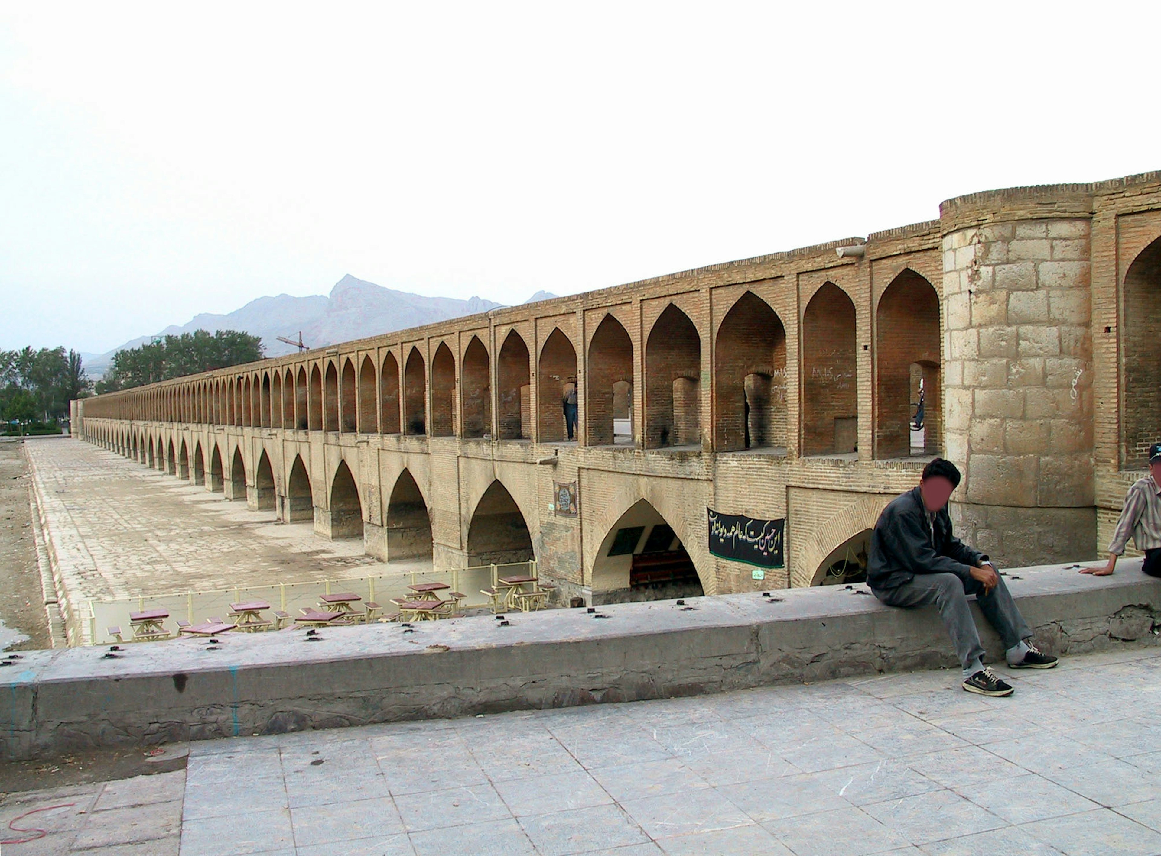 Antico ponte in pietra con archi e paesaggio circostante