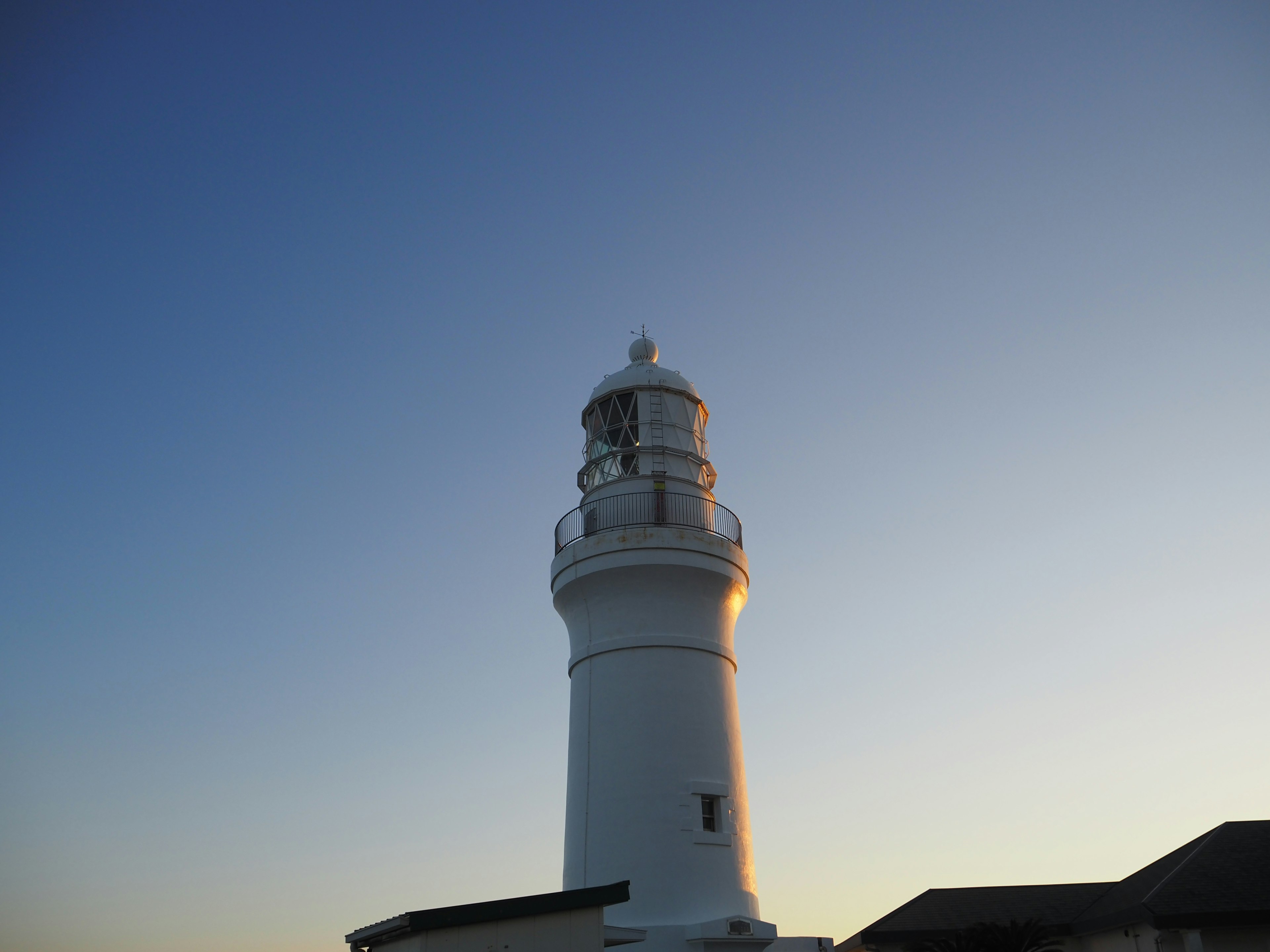 White lighthouse standing under a blue sky