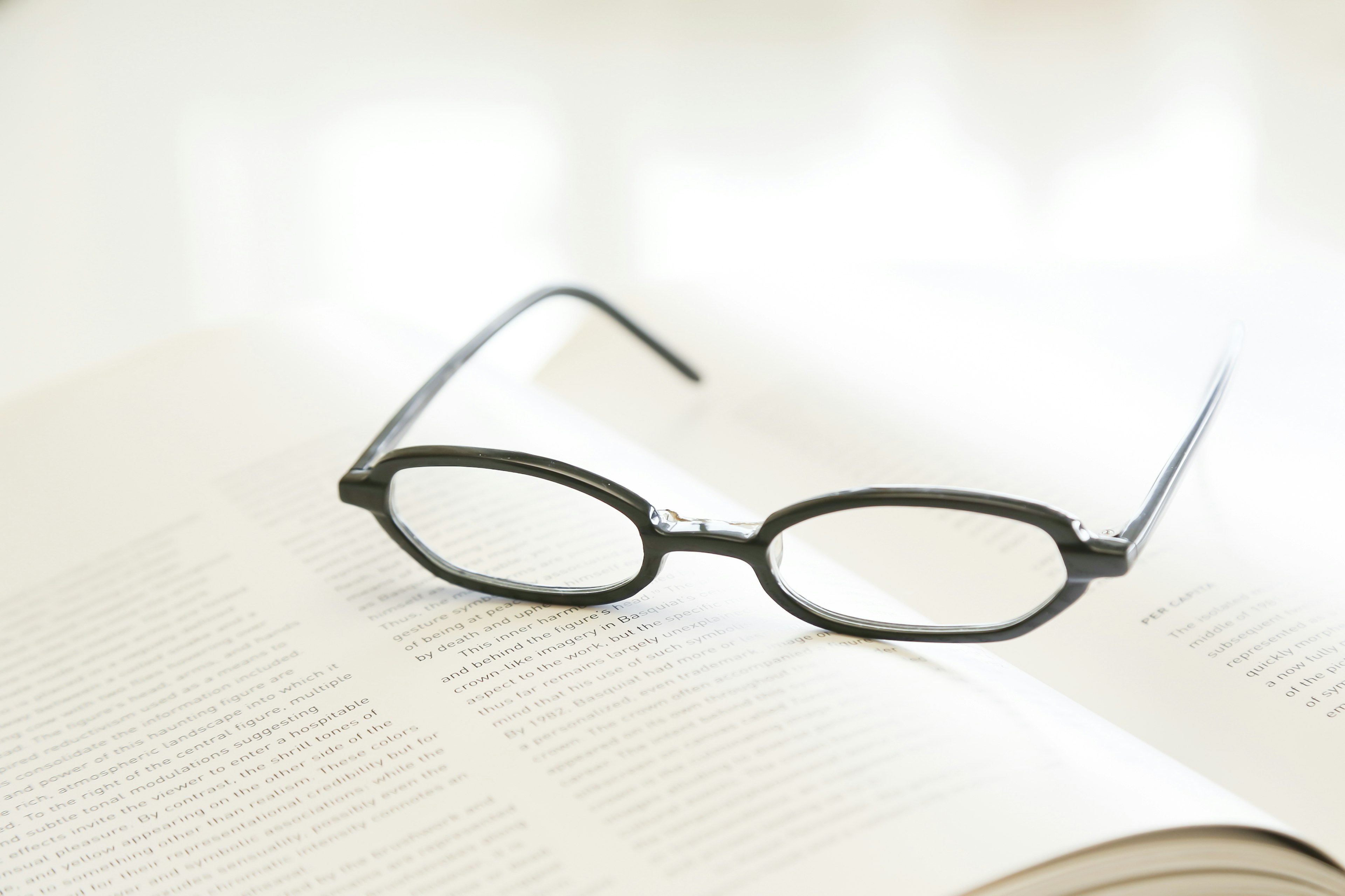 Black-framed glasses resting on an open book