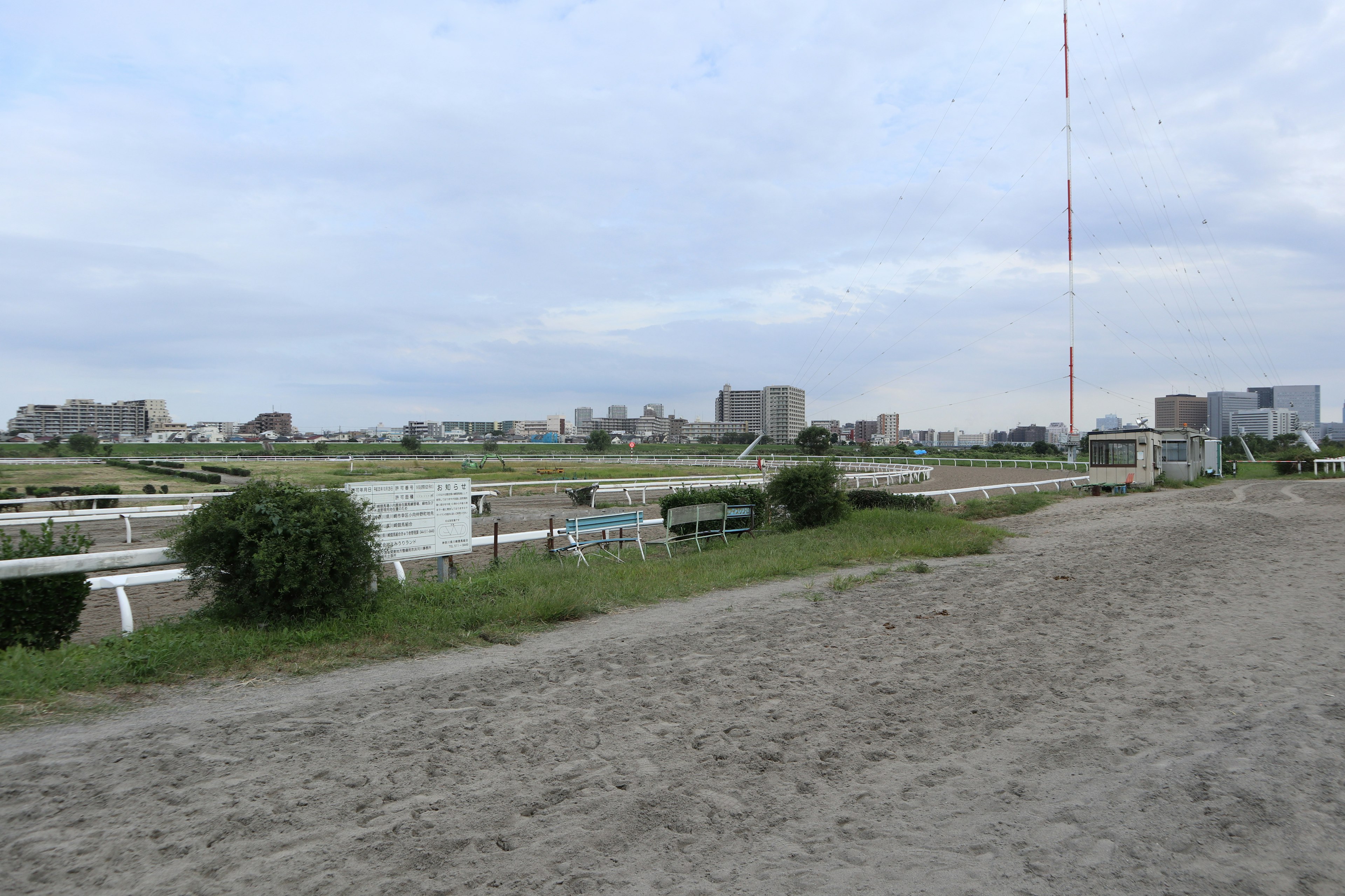 砂地の競馬場の風景と遠くの建物