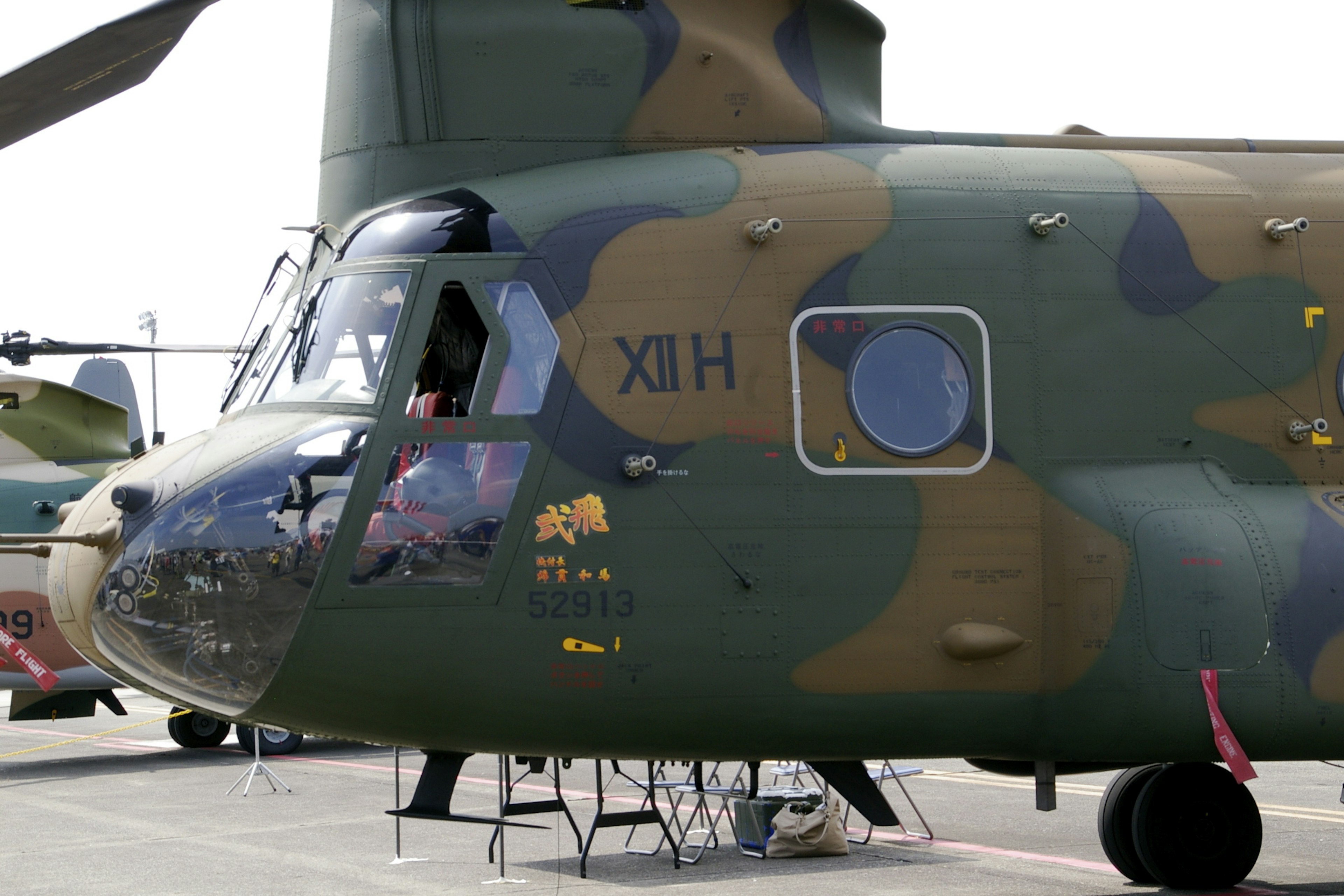 Military helicopter side view featuring camouflage paint and window