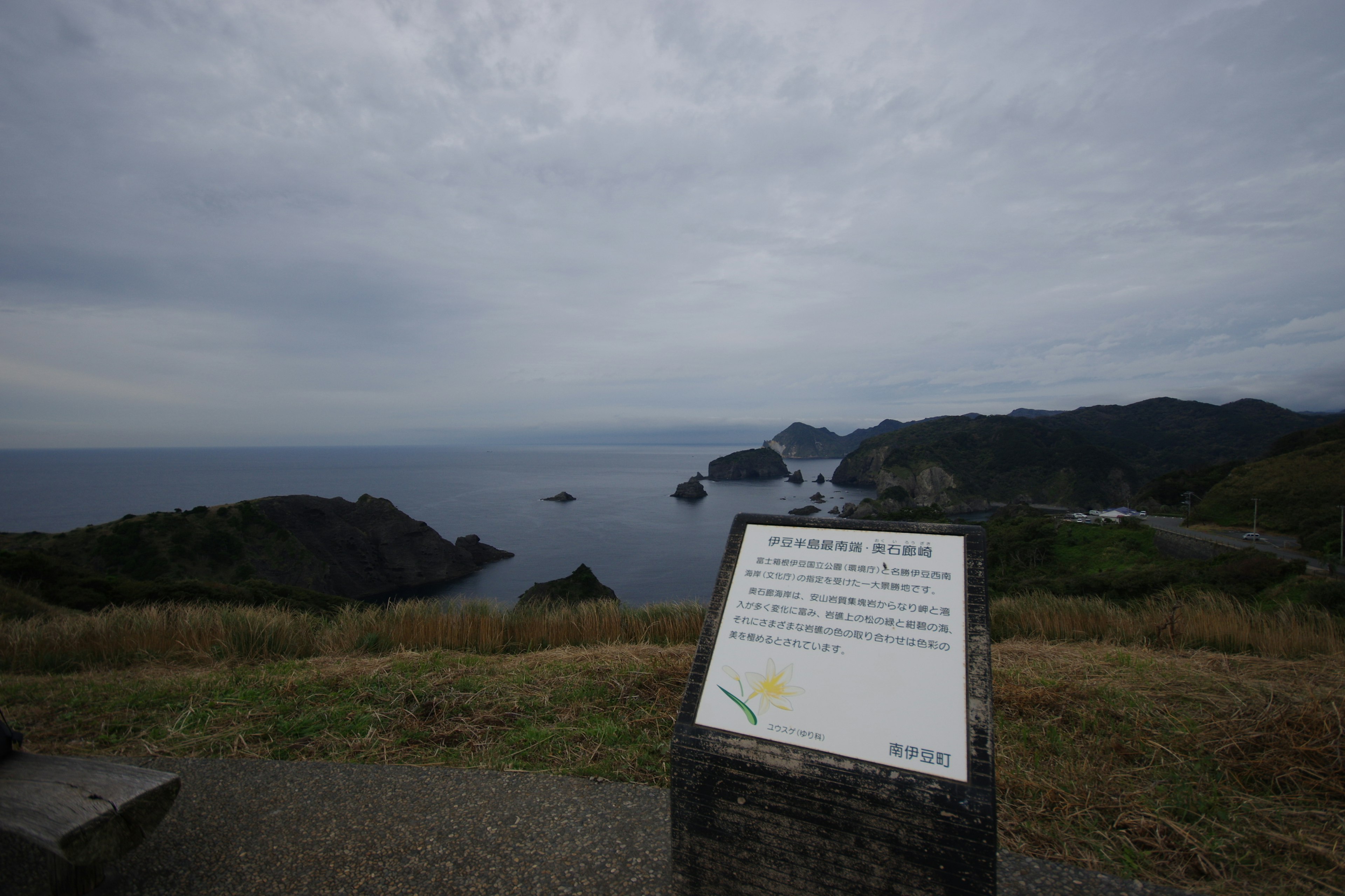 Scenic view of the ocean with a sign in the foreground