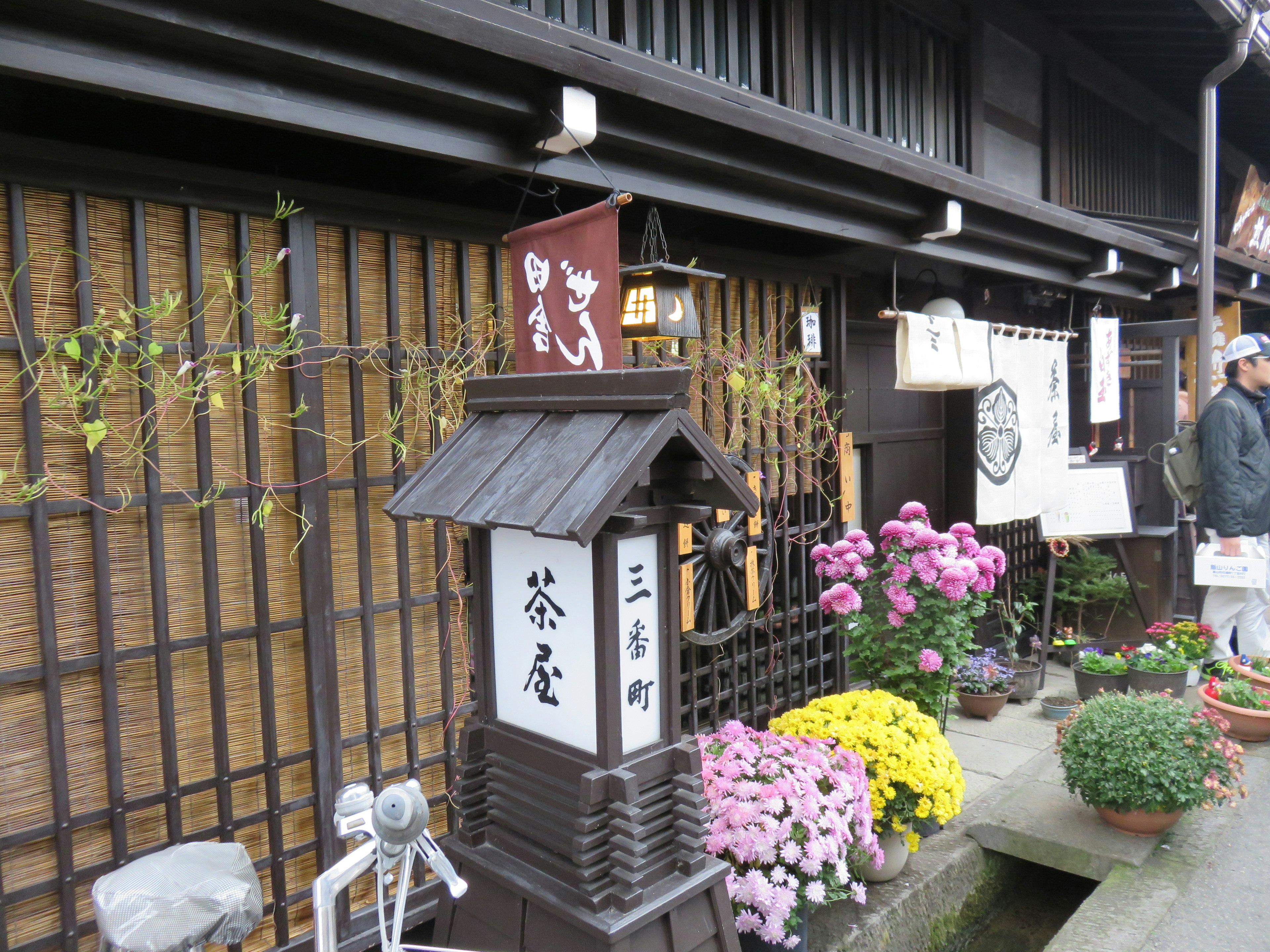 Außenansicht eines traditionellen japanischen Teahauses mit Blumenarrangements