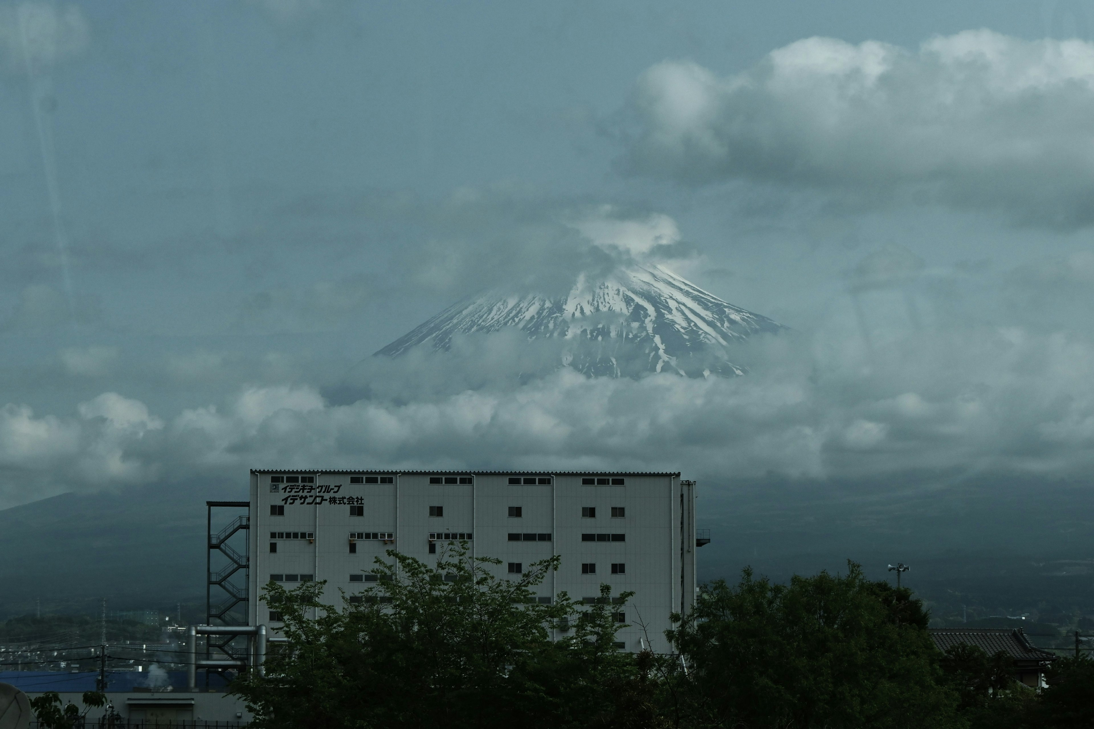 Vista del monte Fuji parzialmente coperto da nuvole con un edificio in primo piano