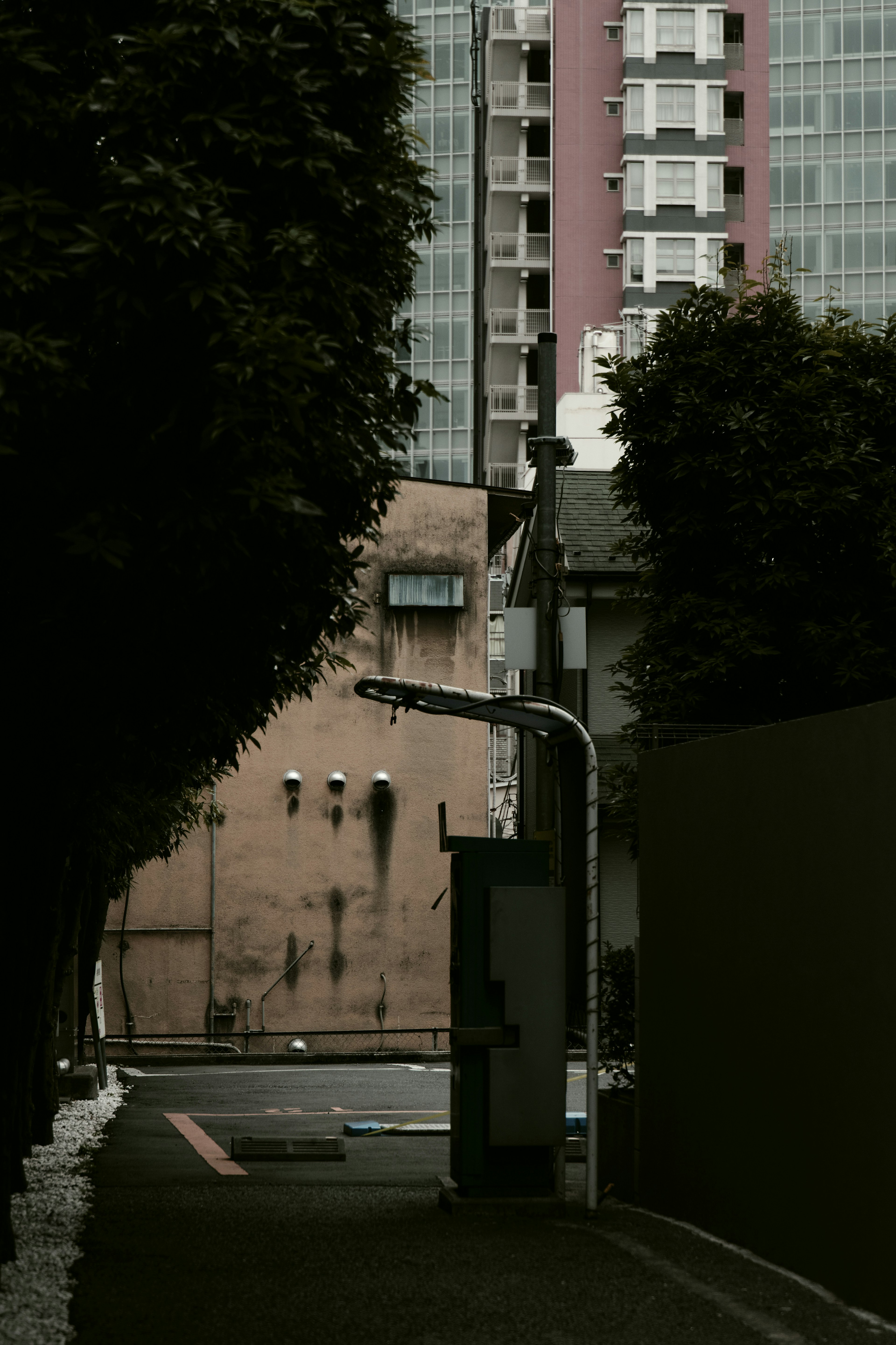 Schmale Gasse mit einem alten Gebäude und hohen Gebäuden im Hintergrund