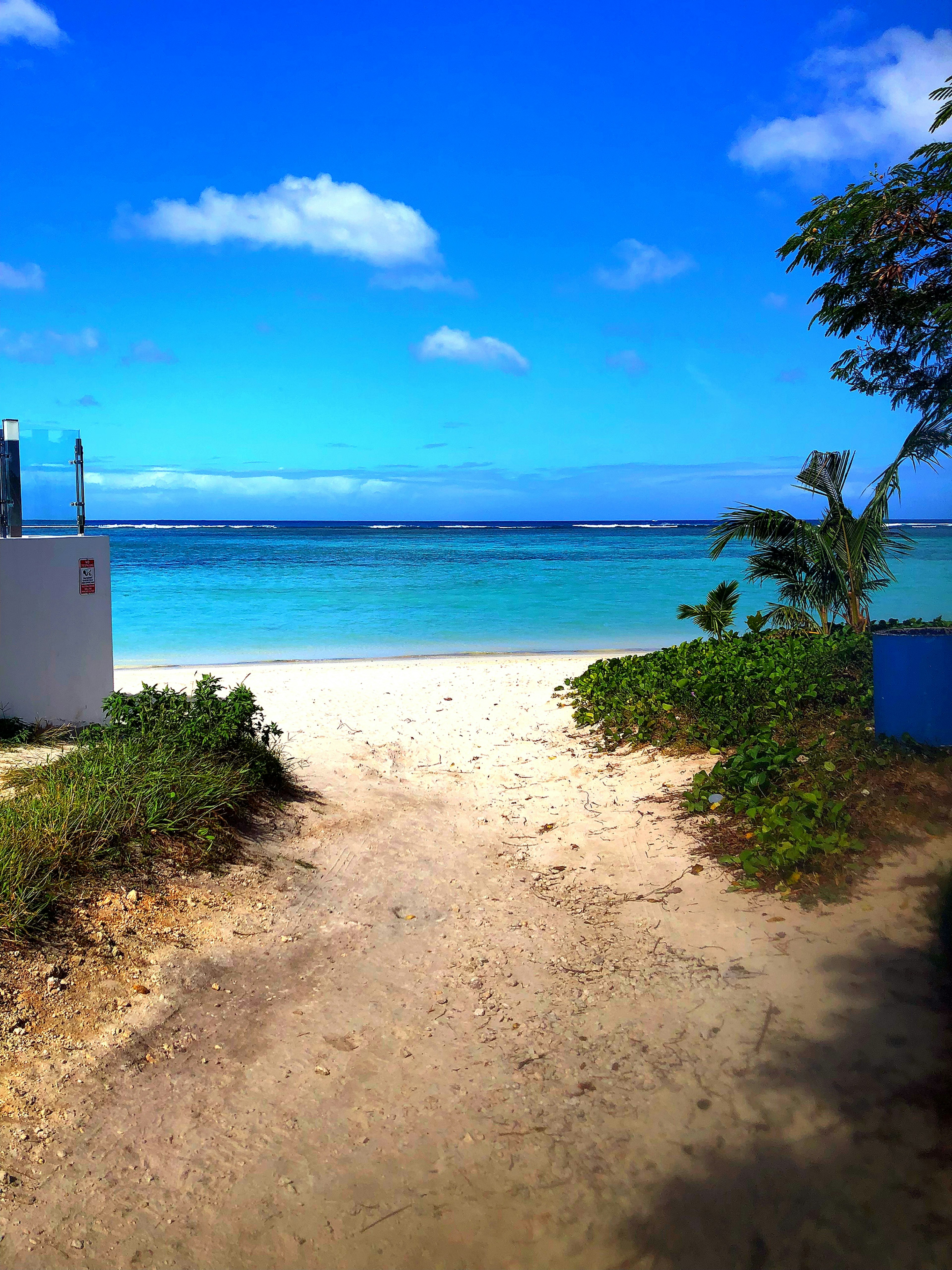 Weg zu einem Strand mit blauem Meer und Himmel