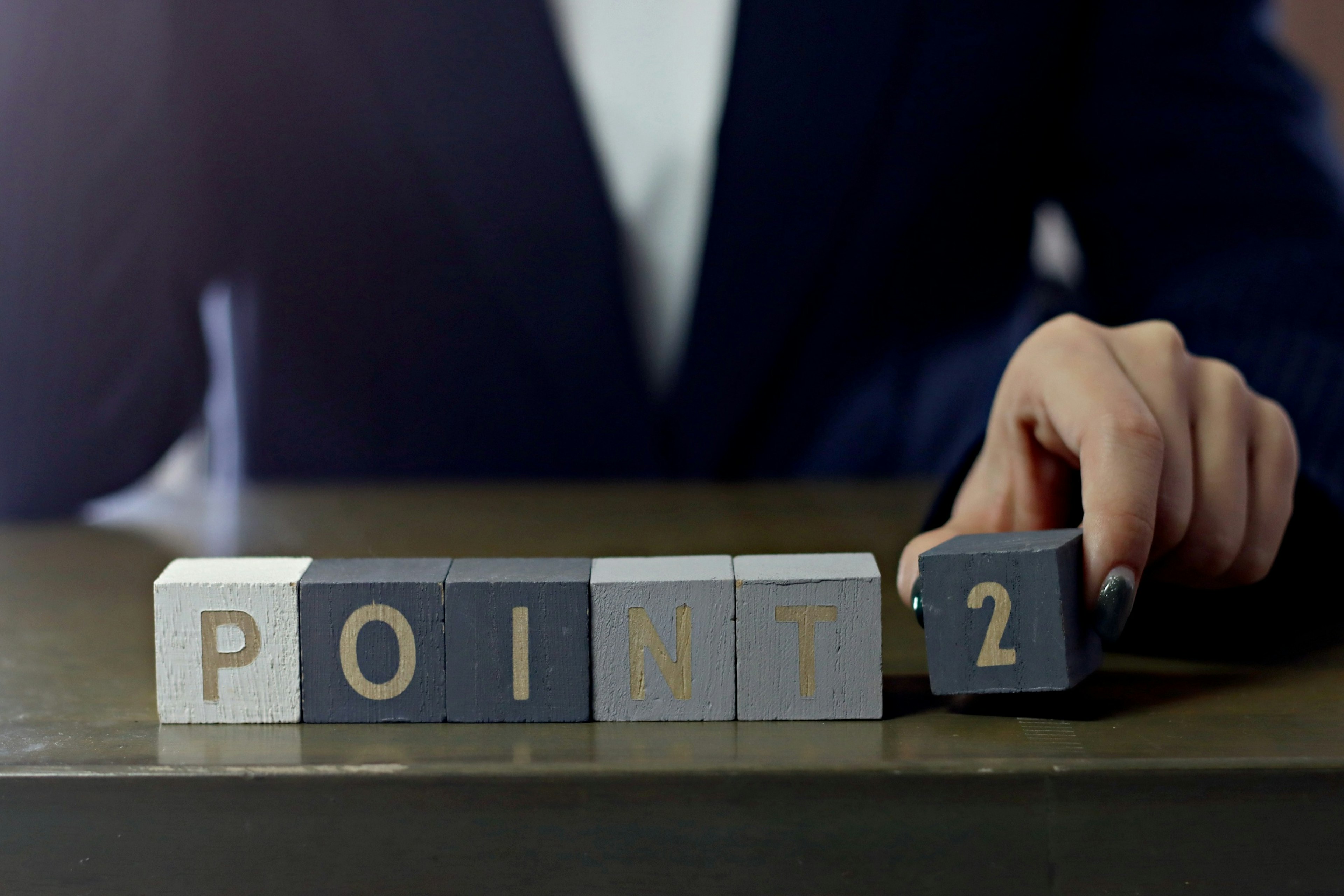 Business professional holding a block labeled Point 2