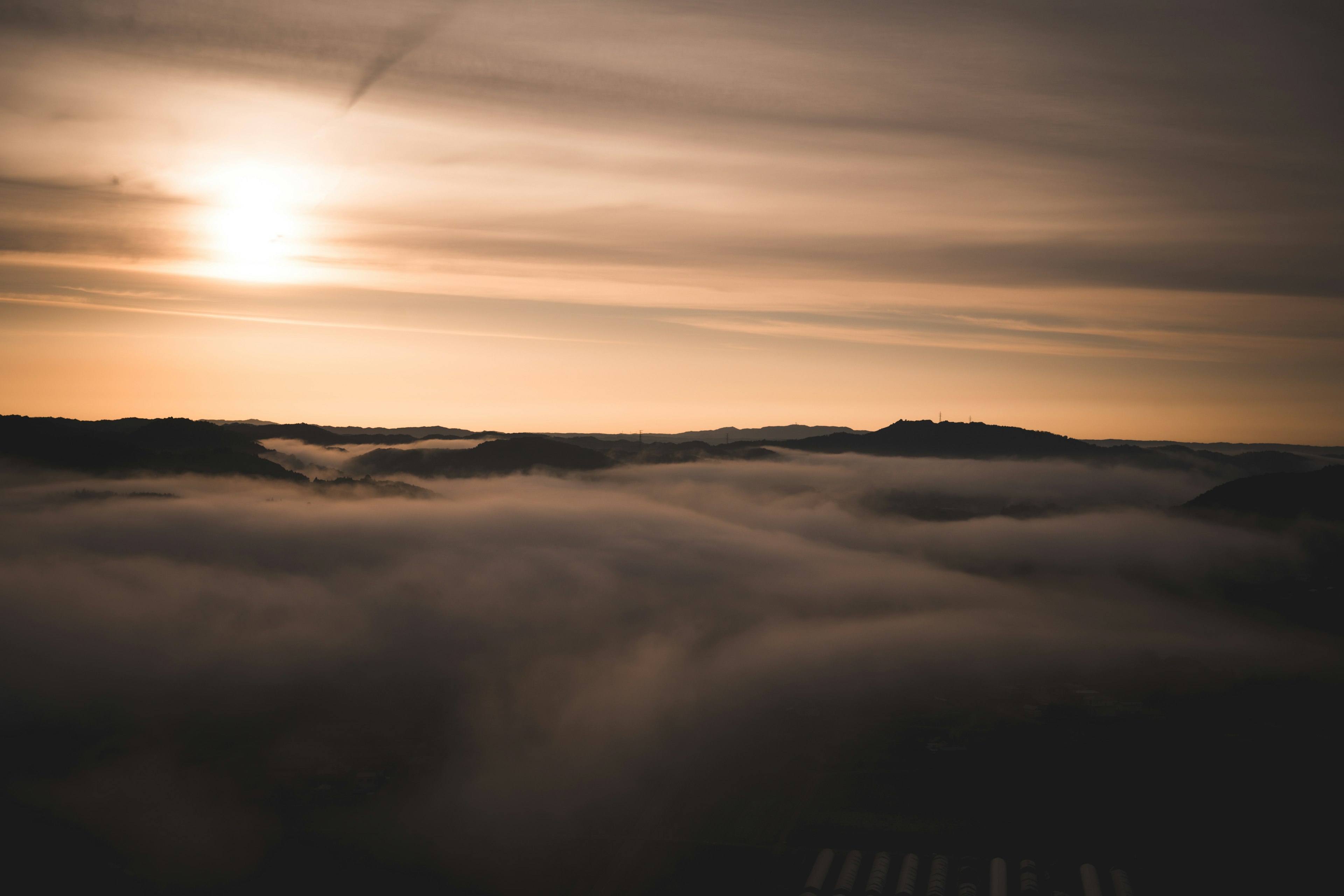 Berge in Nebel gehüllt mit sanftem Licht des Sonnenuntergangs