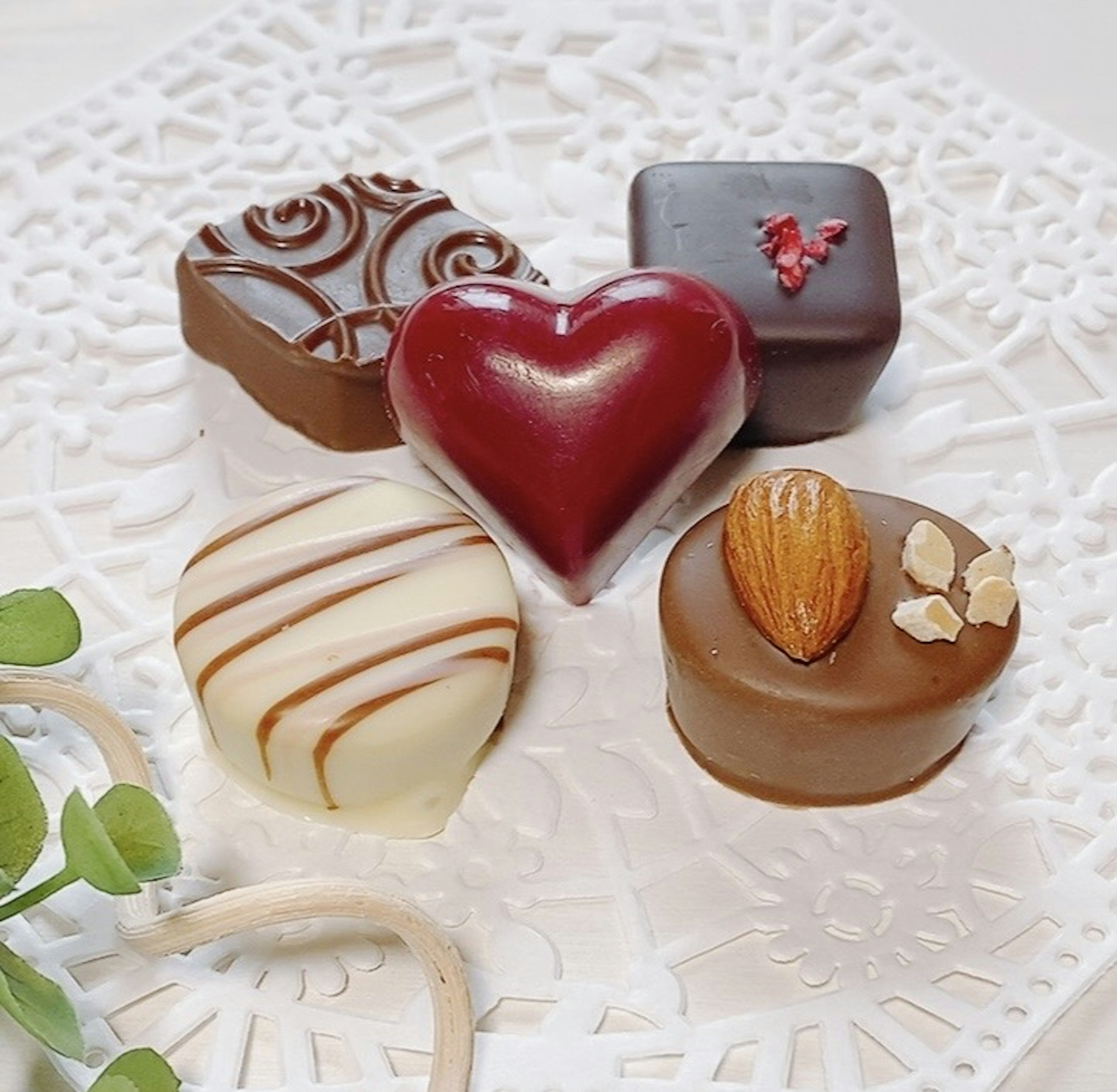 A beautifully arranged plate of assorted chocolates in various shapes and colors