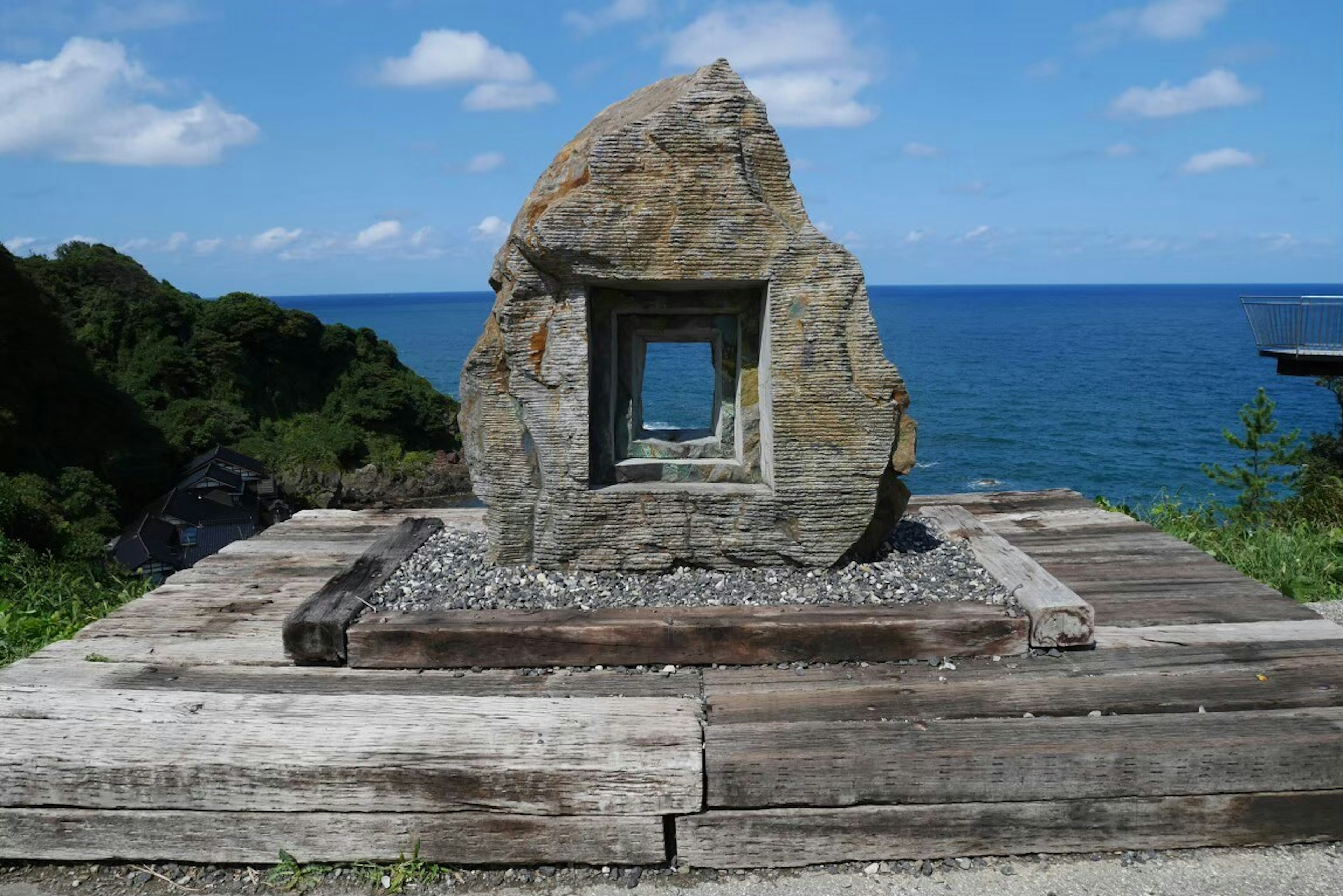 Steinskulptur mit quadratischer Öffnung vor dem Ozean