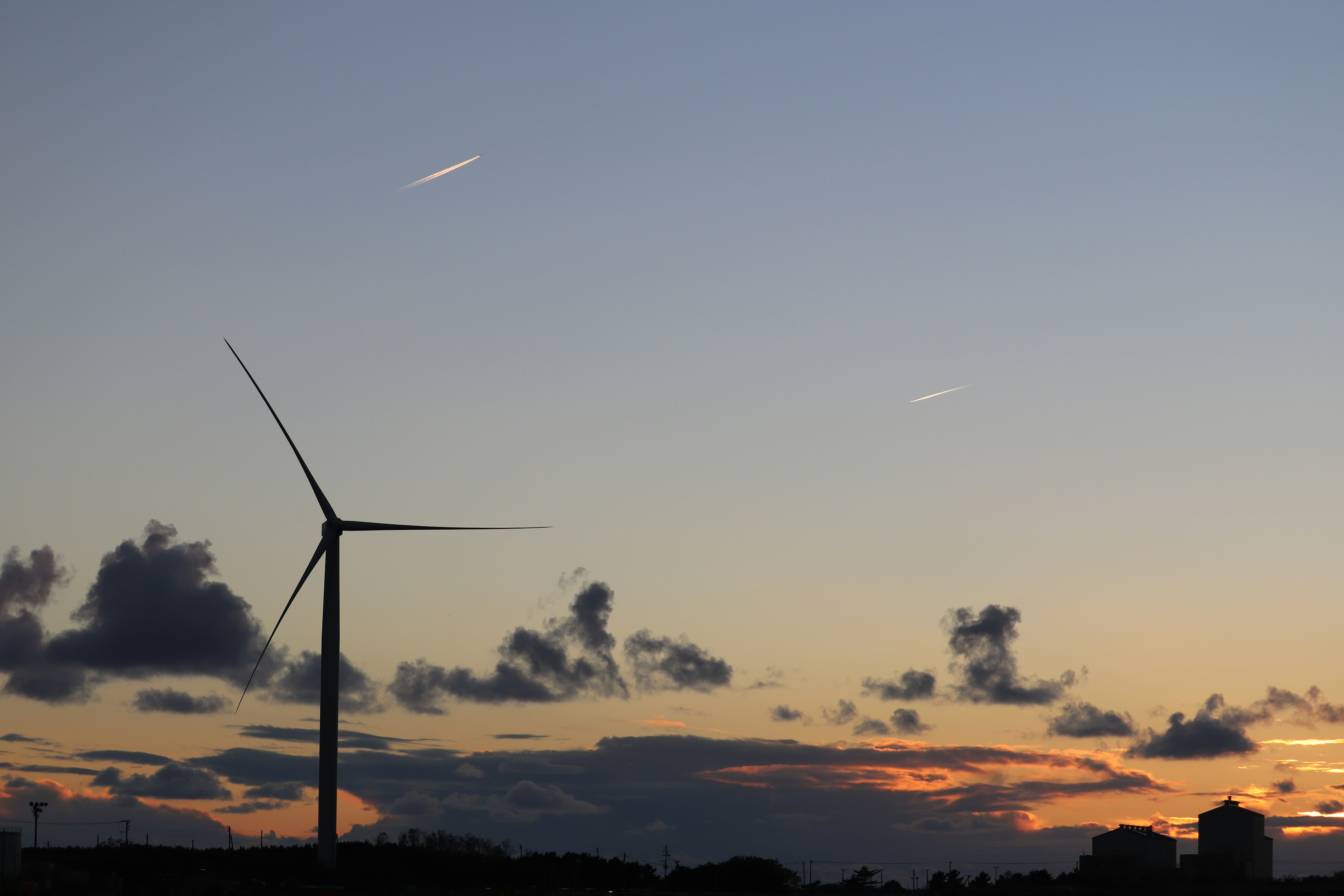 Windkraftanlage vor einem lebhaften Sonnenuntergangshimmel