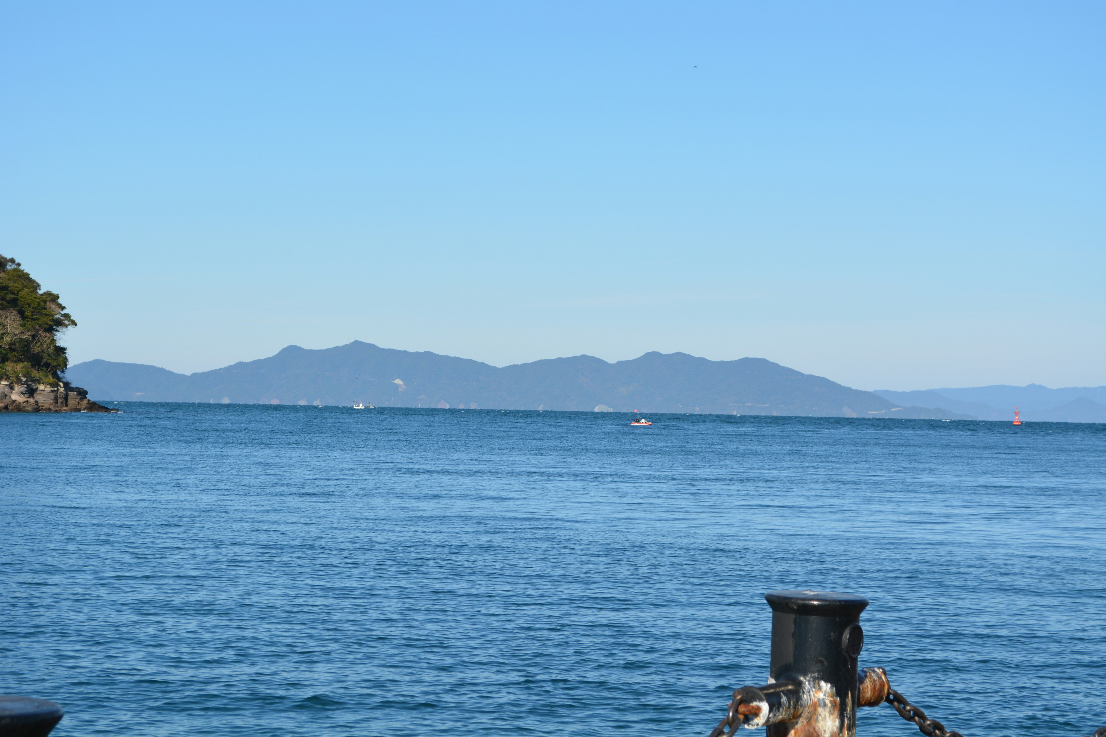 Calm sea with distant mountains in the background