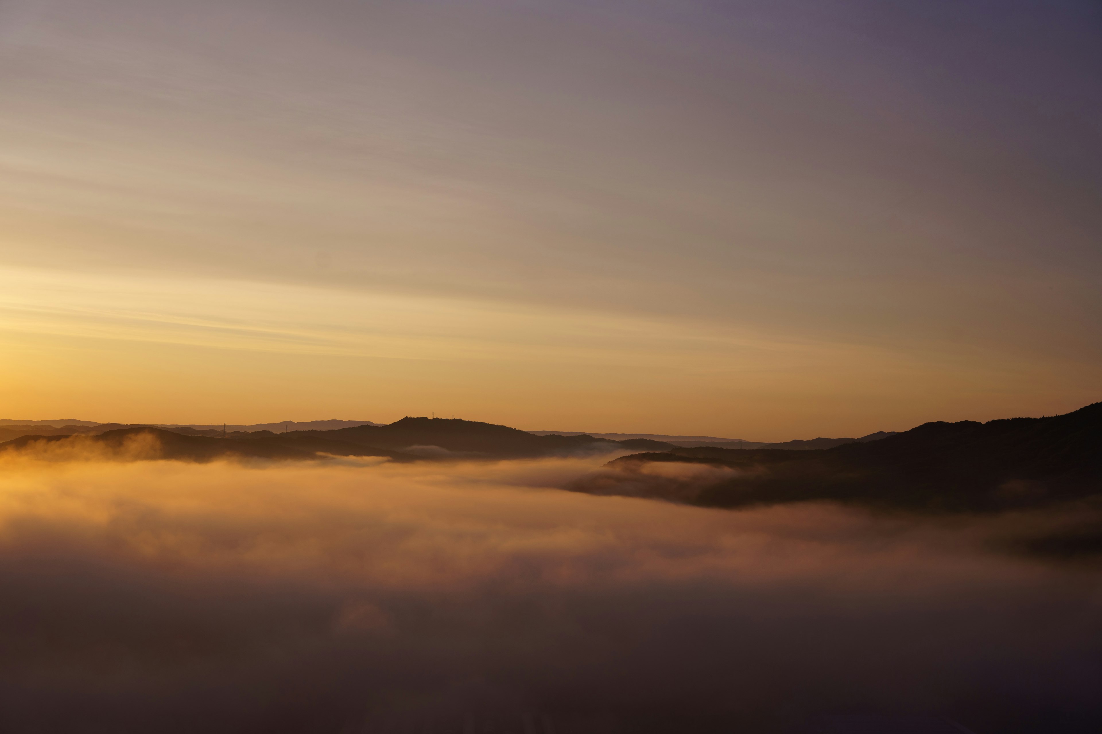 Montagnes enveloppées de brouillard avec un ciel de coucher de soleil magnifique