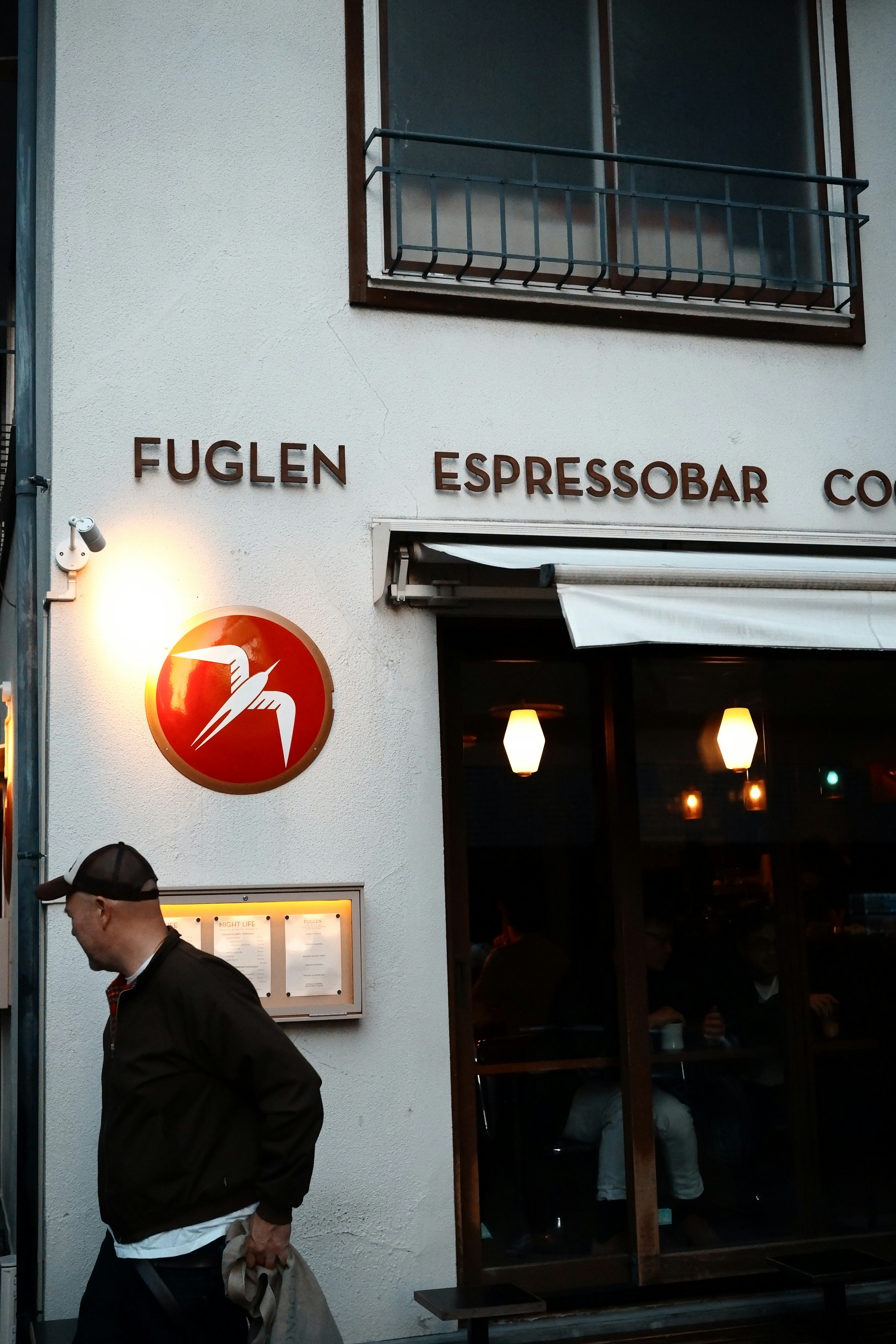 カフェの外観にある赤いロゴと看板を持つFuglen Espressobarの入り口