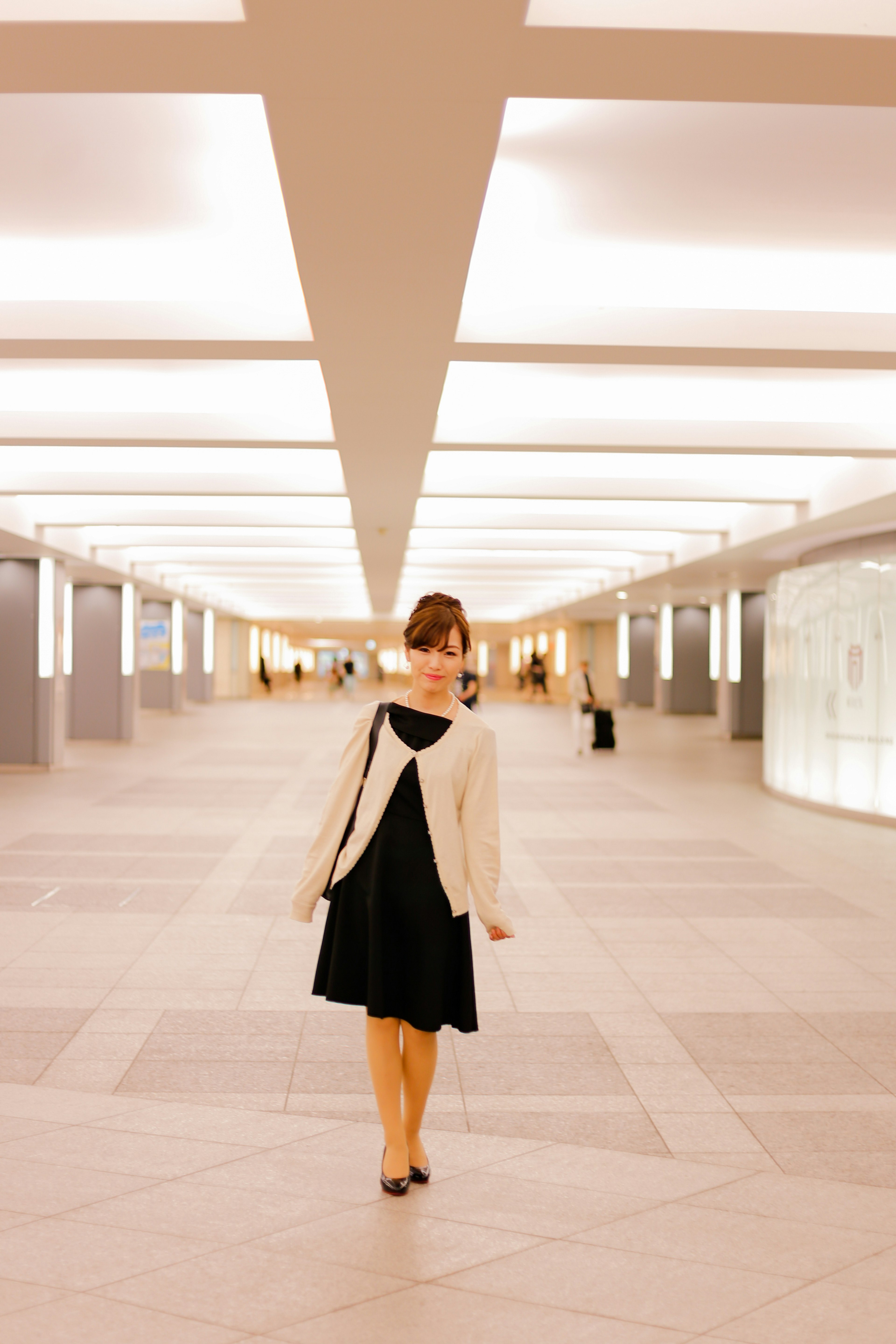 Une femme marchant dans un couloir moderne avec un éclairage lumineux