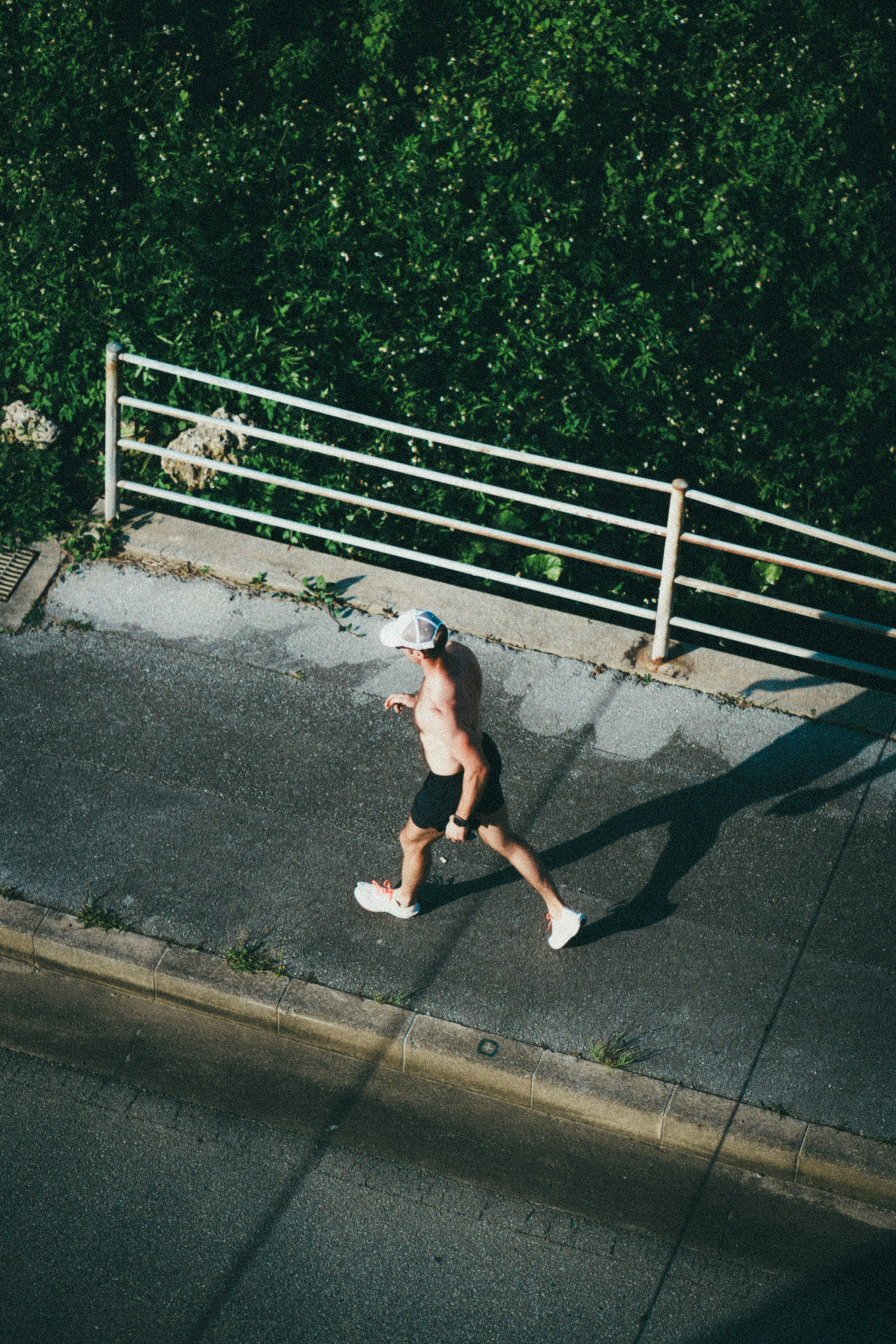 緑の背景を背にした男性がランニングしている様子