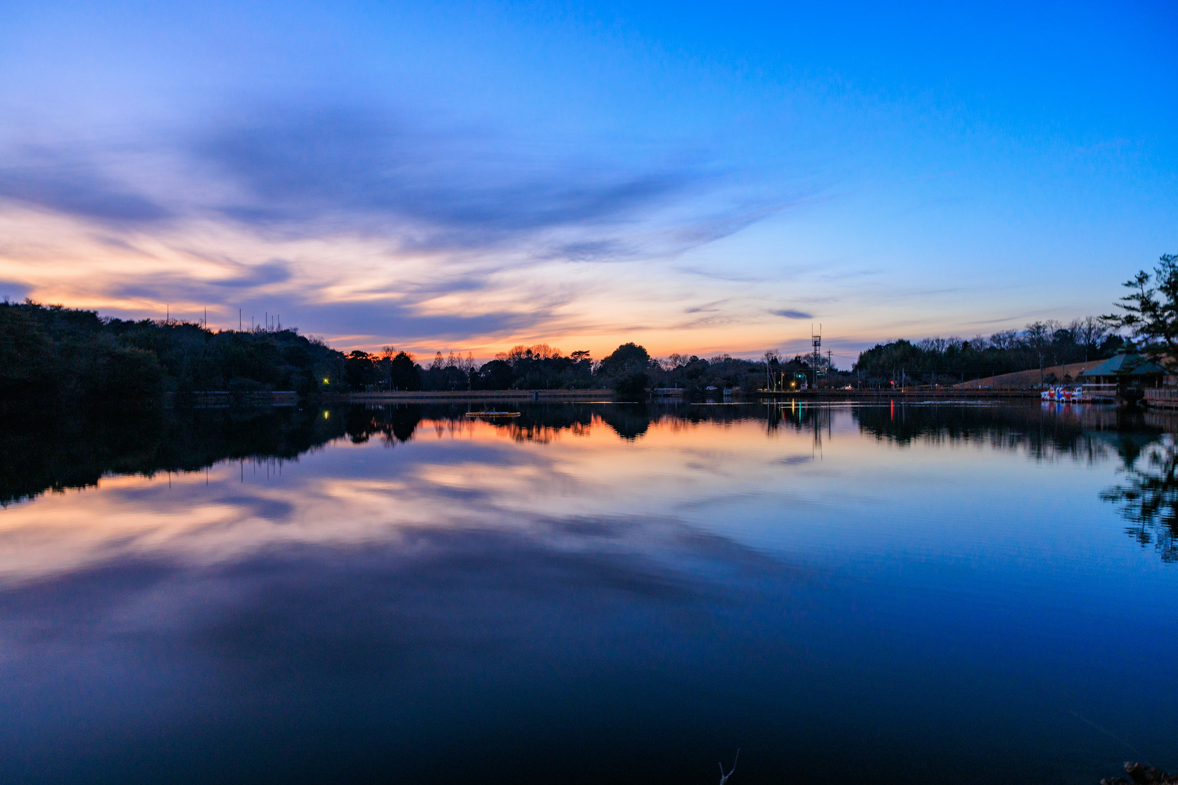 ทิวทัศน์ทะเลสาบที่เงียบสงบสะท้อนพระอาทิตย์ตกที่สวยงาม