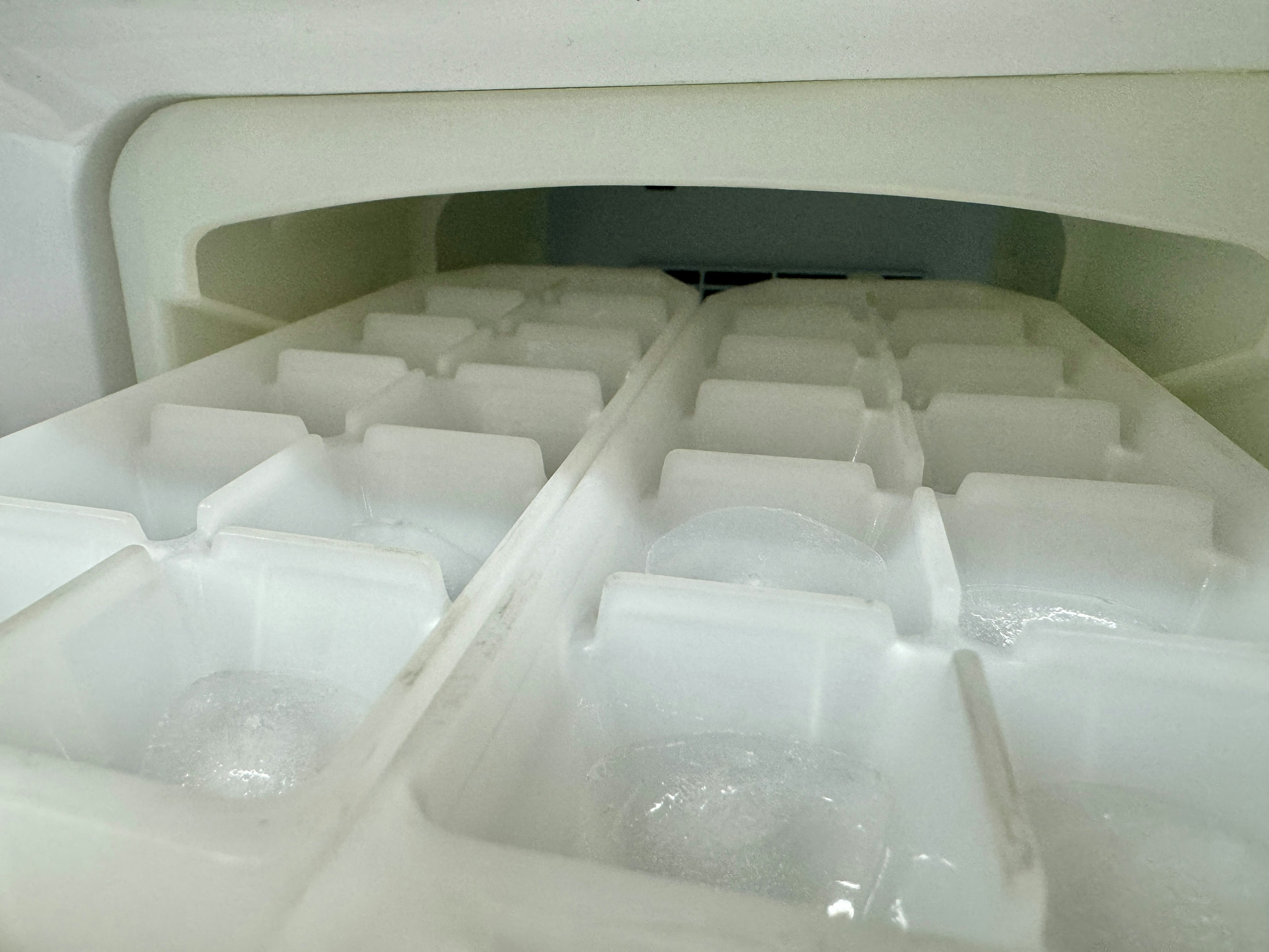 Dekat cetakan es di dalam freezer cetakan es putih tersusun rapi