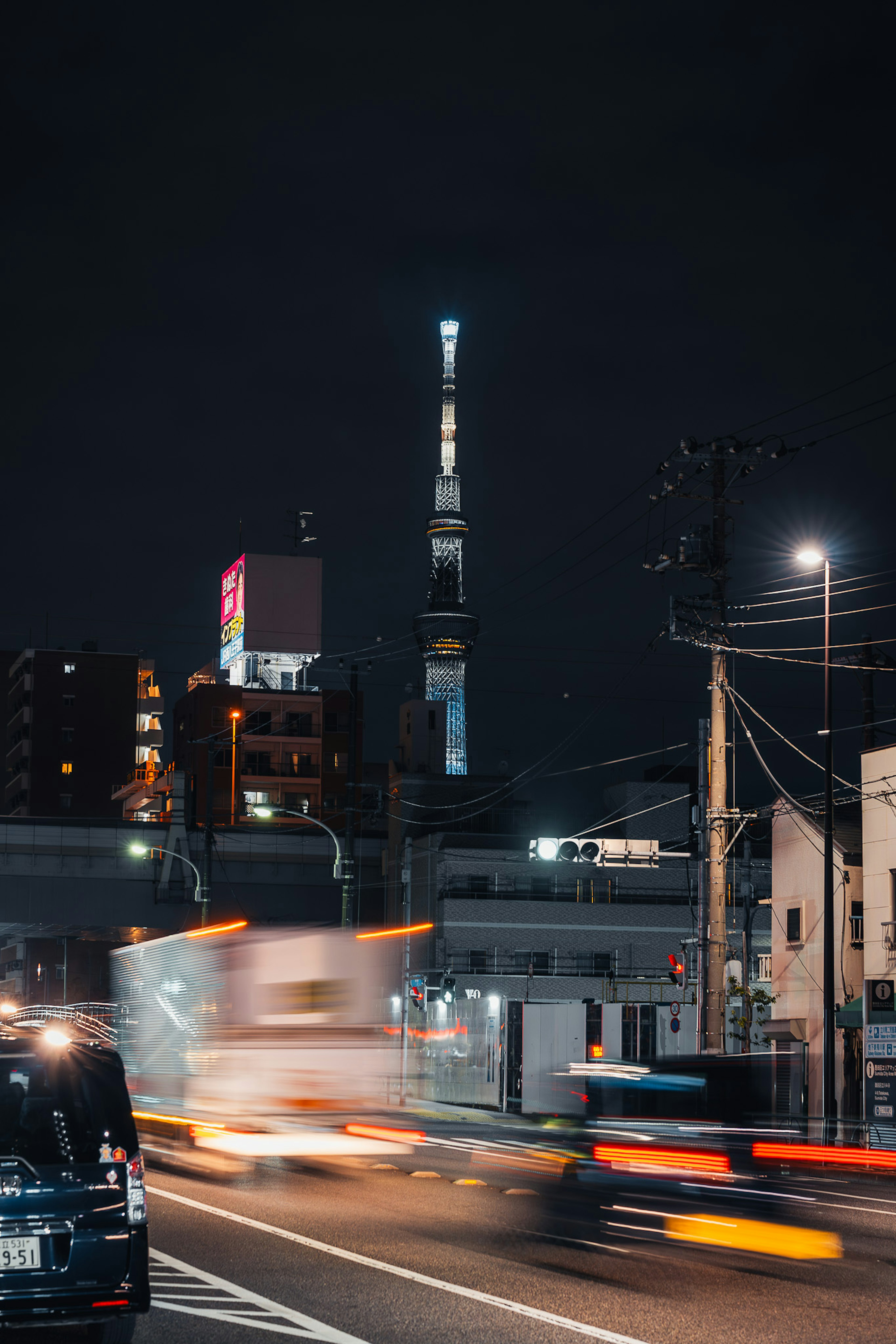 東京タワーが夜空に輝く都市の風景車の流れが感じられる