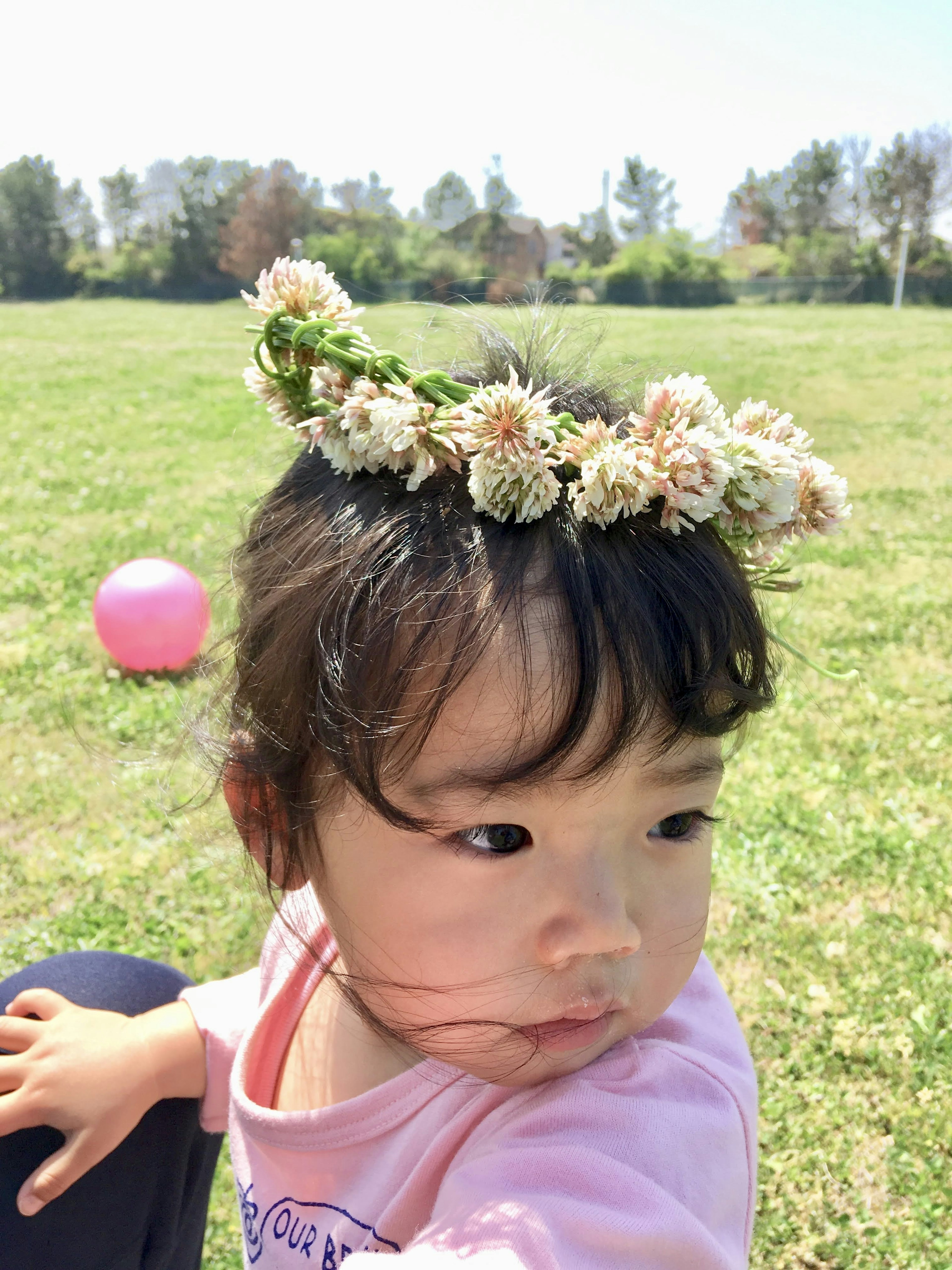 A child wearing a flower crown in a park setting