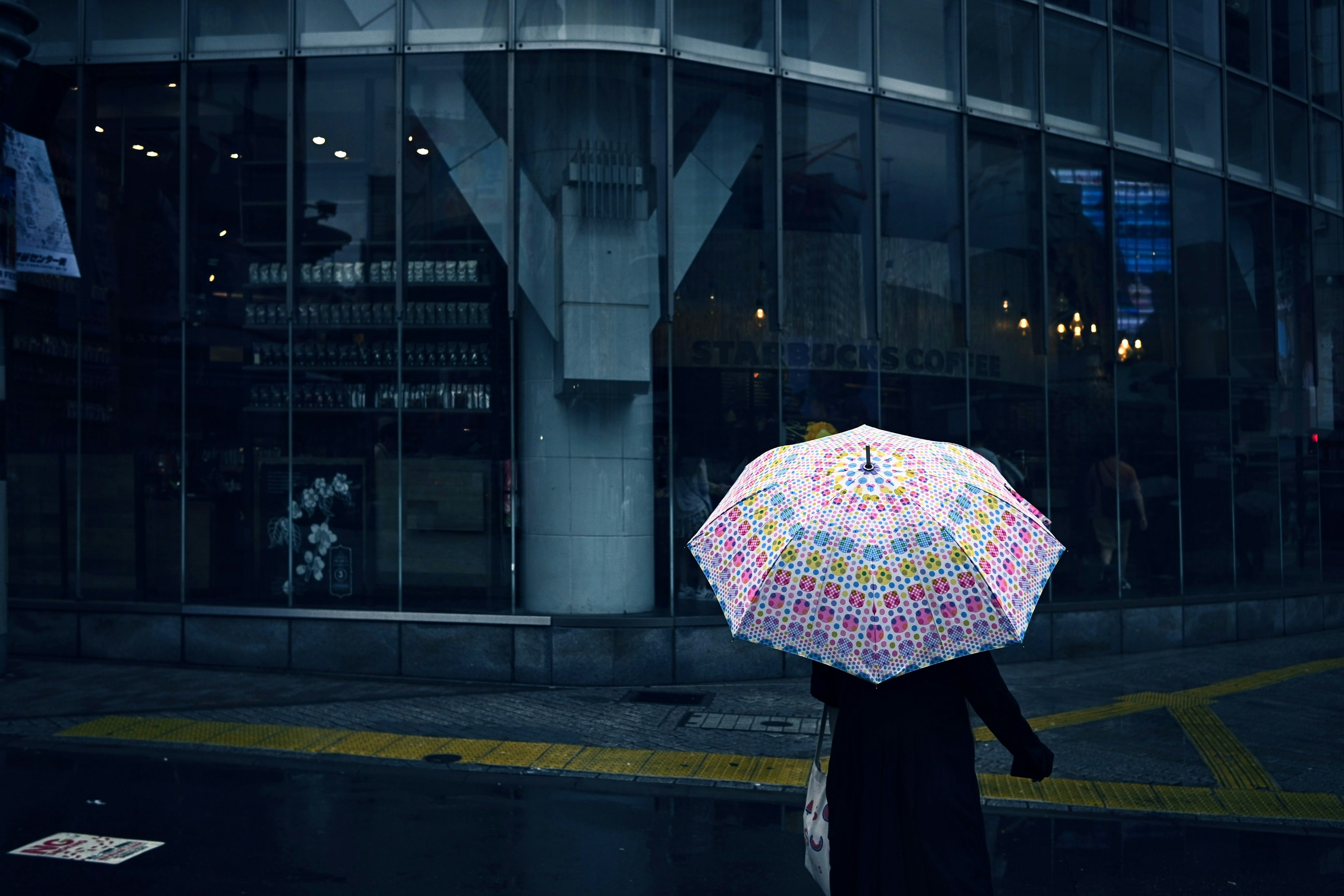 都市の雨の日にカラフルな傘を持った人が歩いている