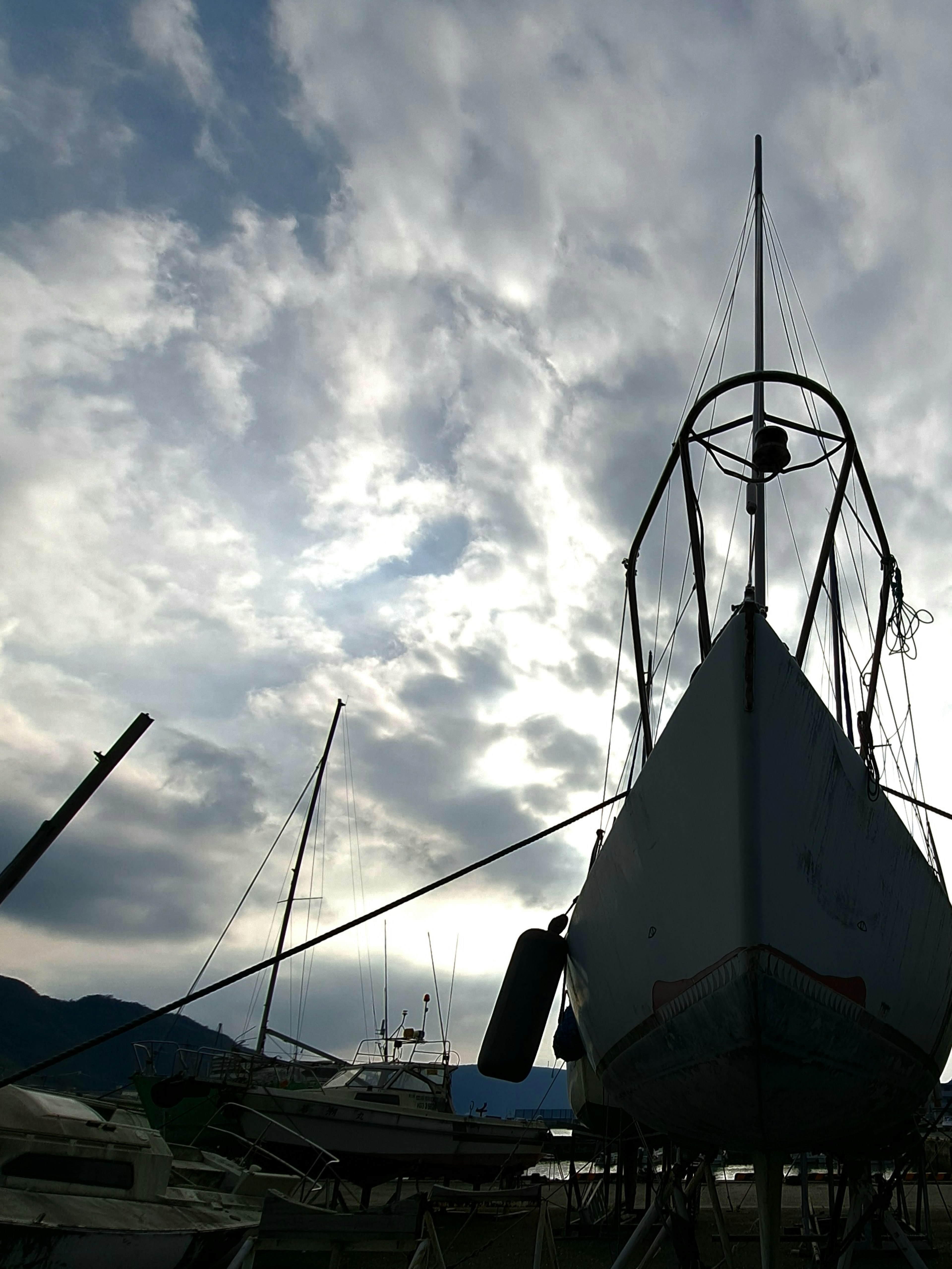 Silhouette of a boat docked under a cloudy sky