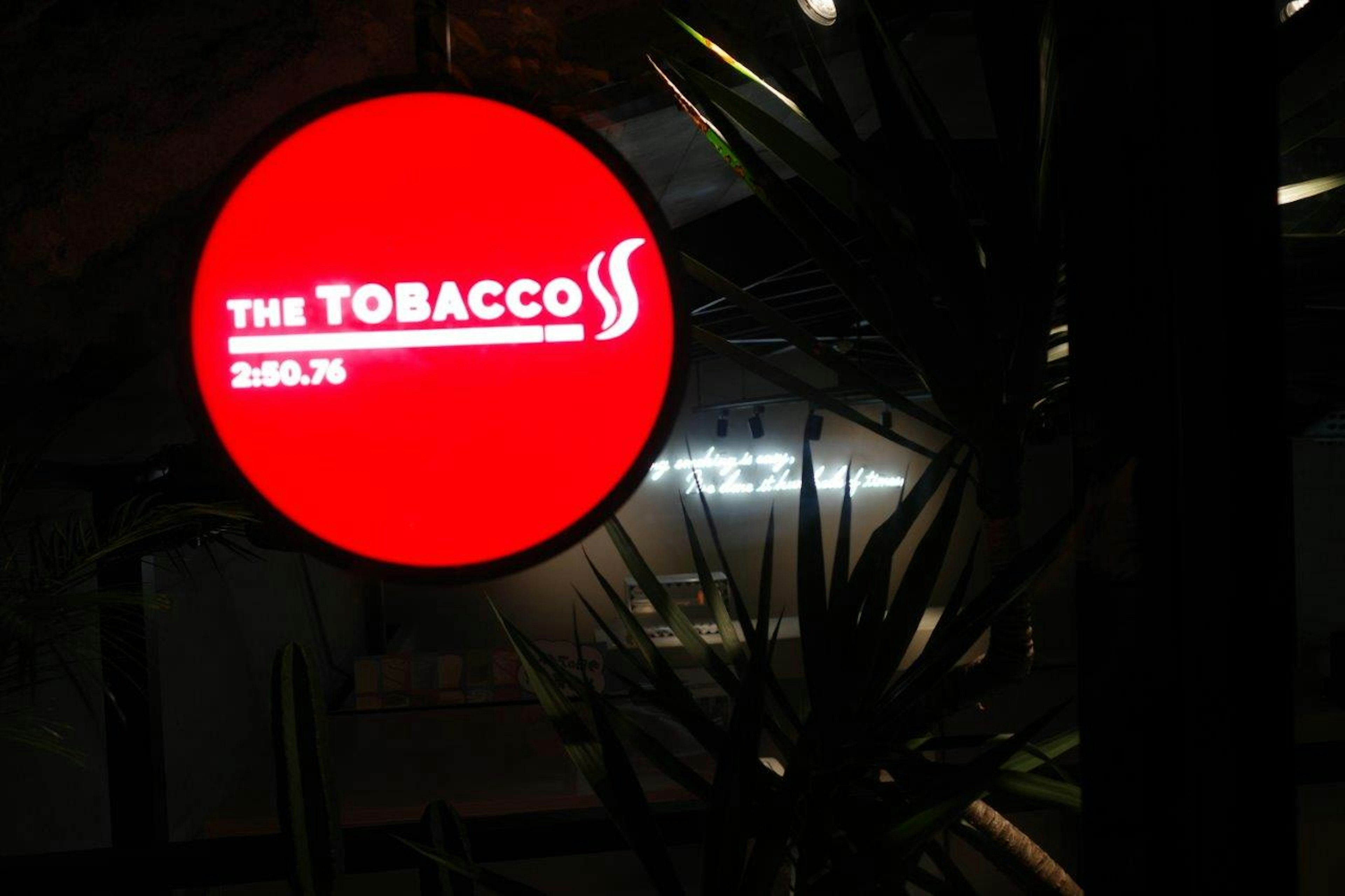 赤い円形の看板に「THE TOBACCO」と書かれている