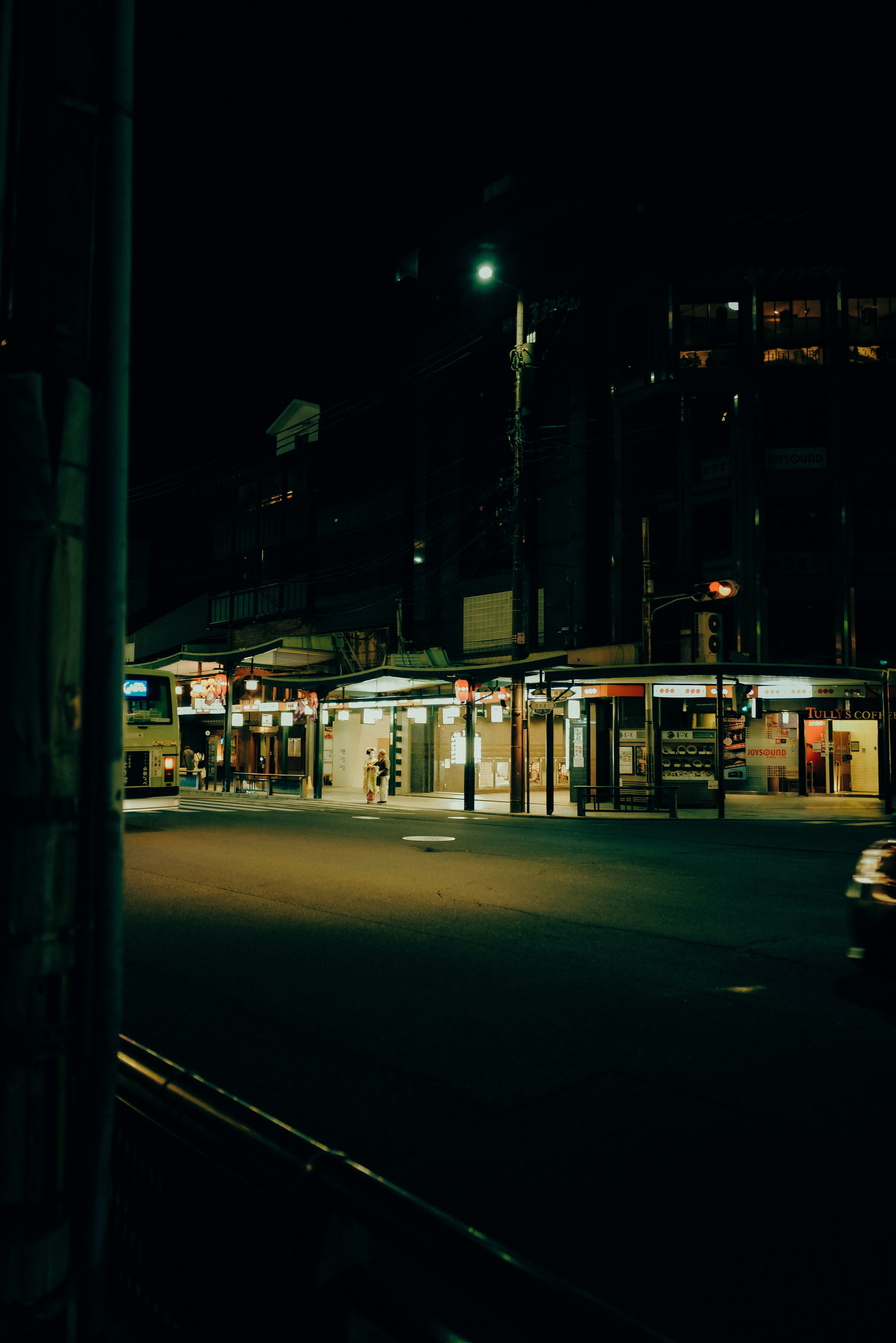 Quiet street with shops and cars at night