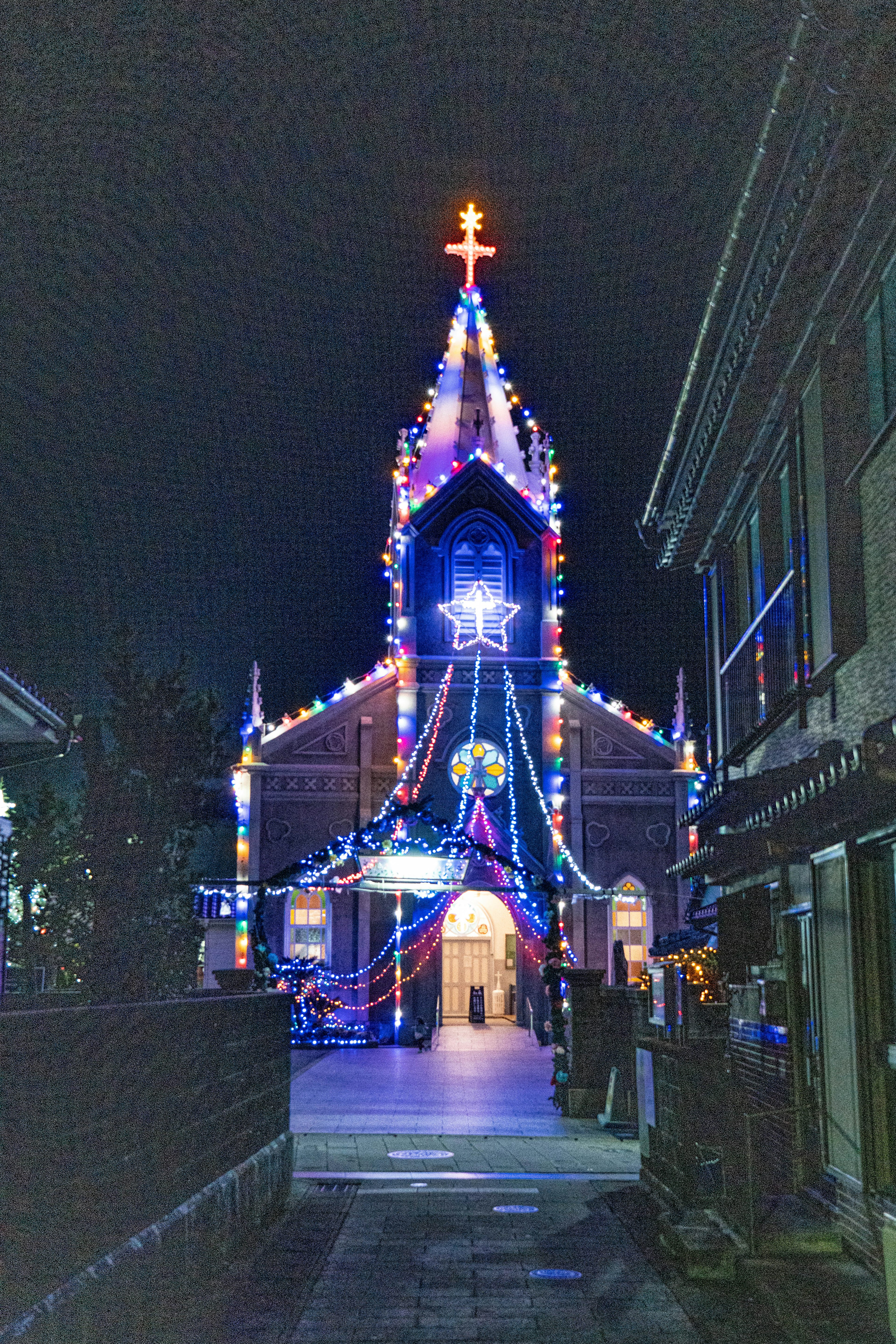 Fachada de la iglesia adornada con luces coloridas de noche