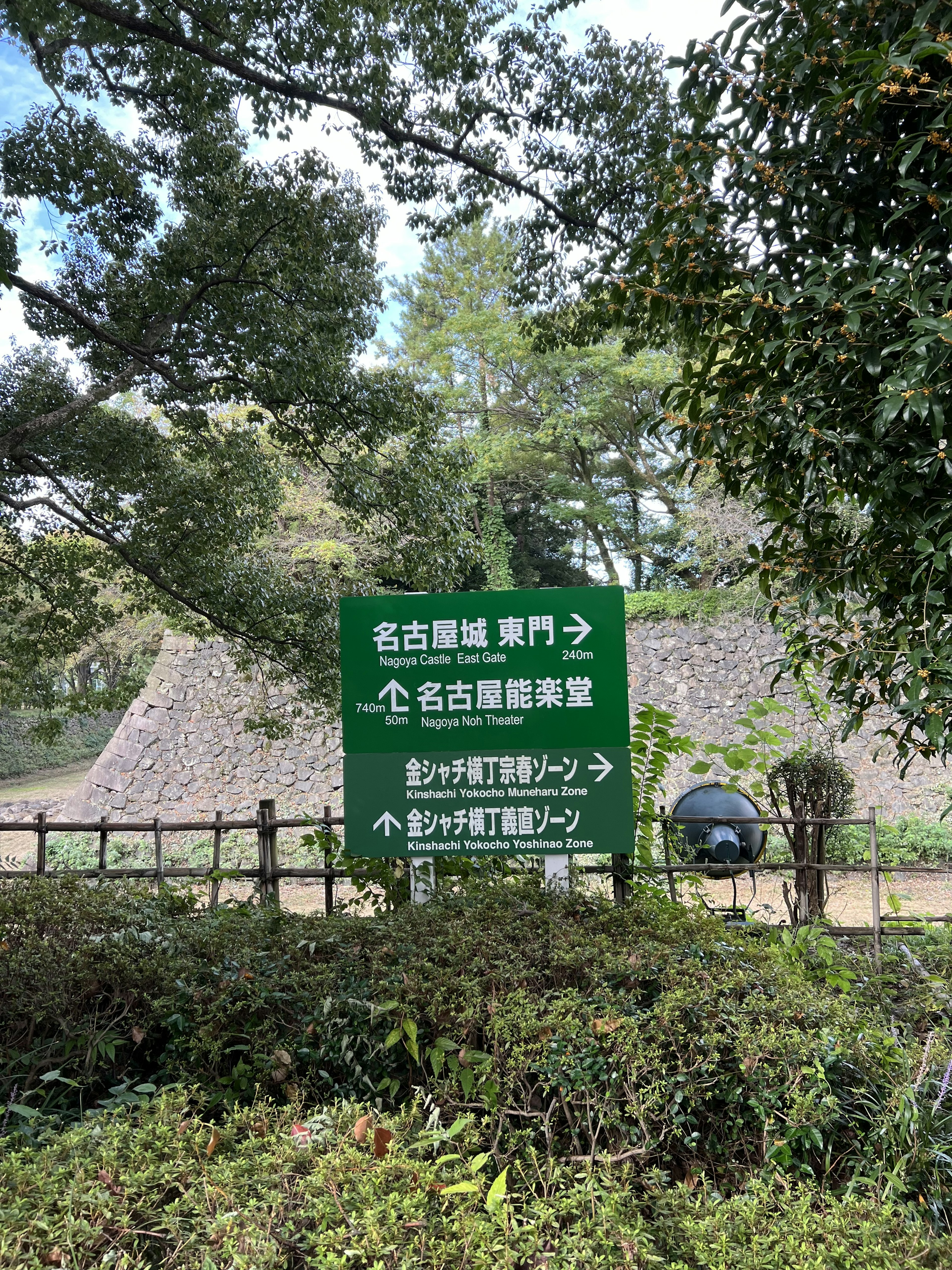 Green sign with directional arrows in a natural setting