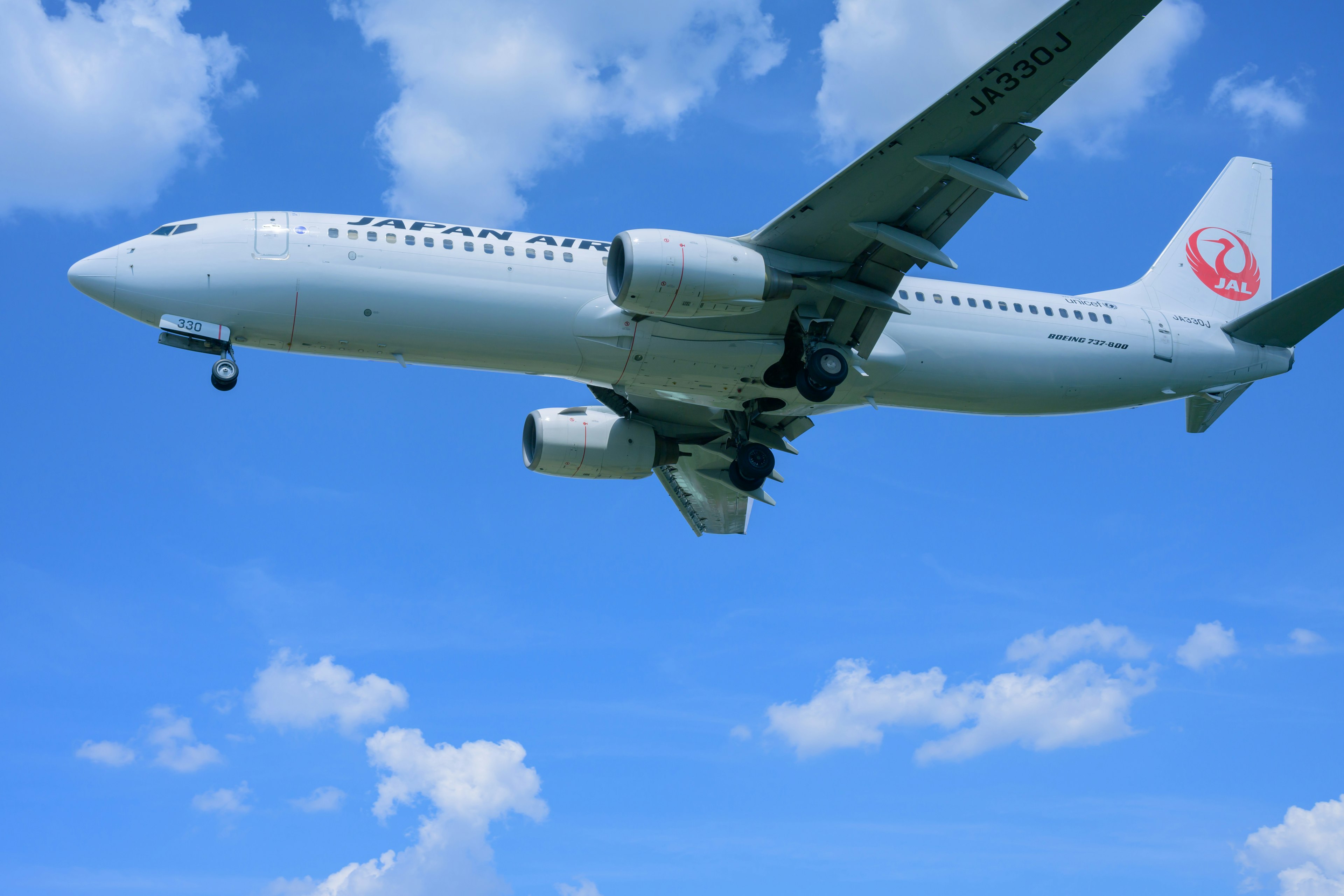 青空を背景にした日本航空の飛行機が飛行中