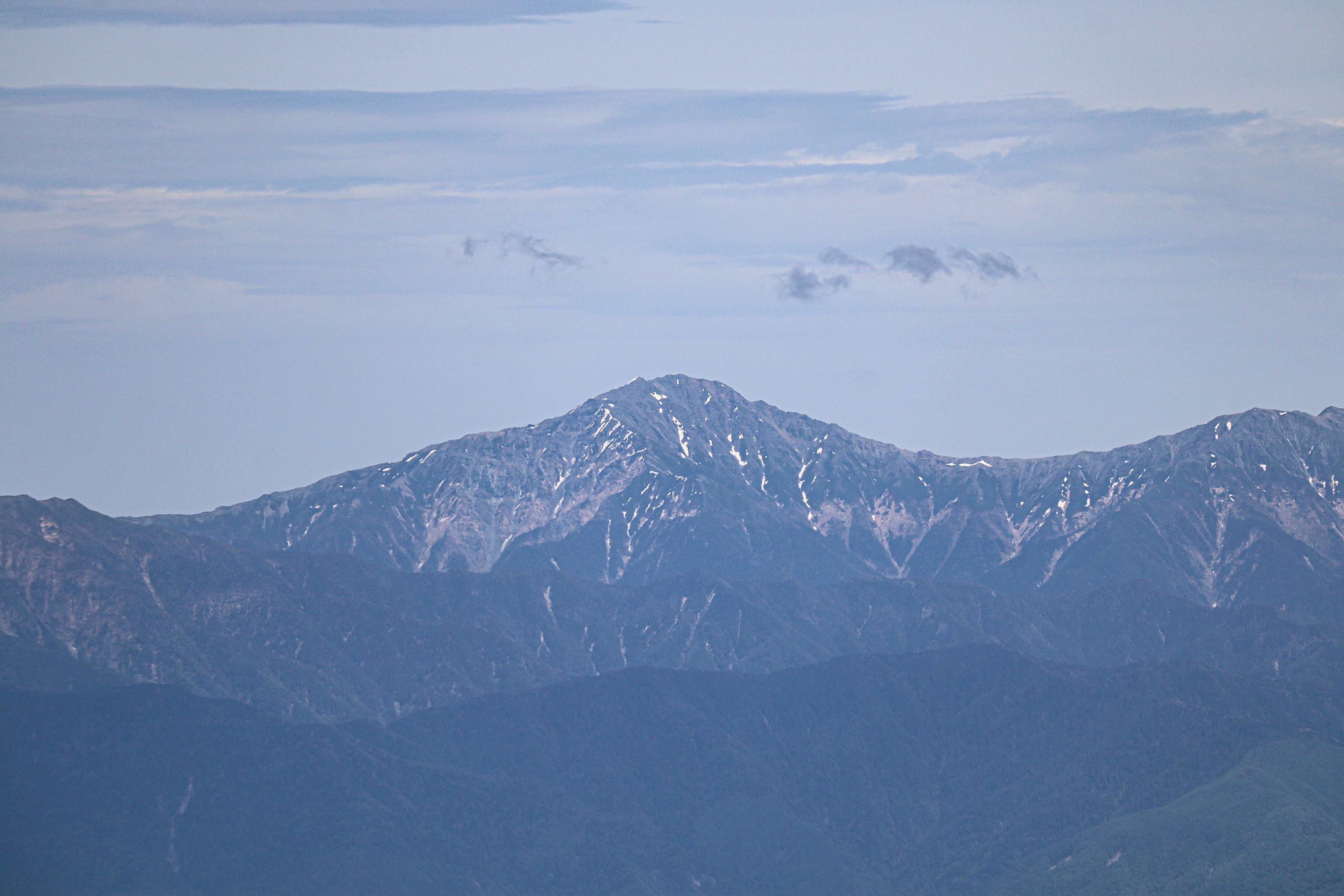 Montagnes lointaines couvertes de neige sous un ciel bleu